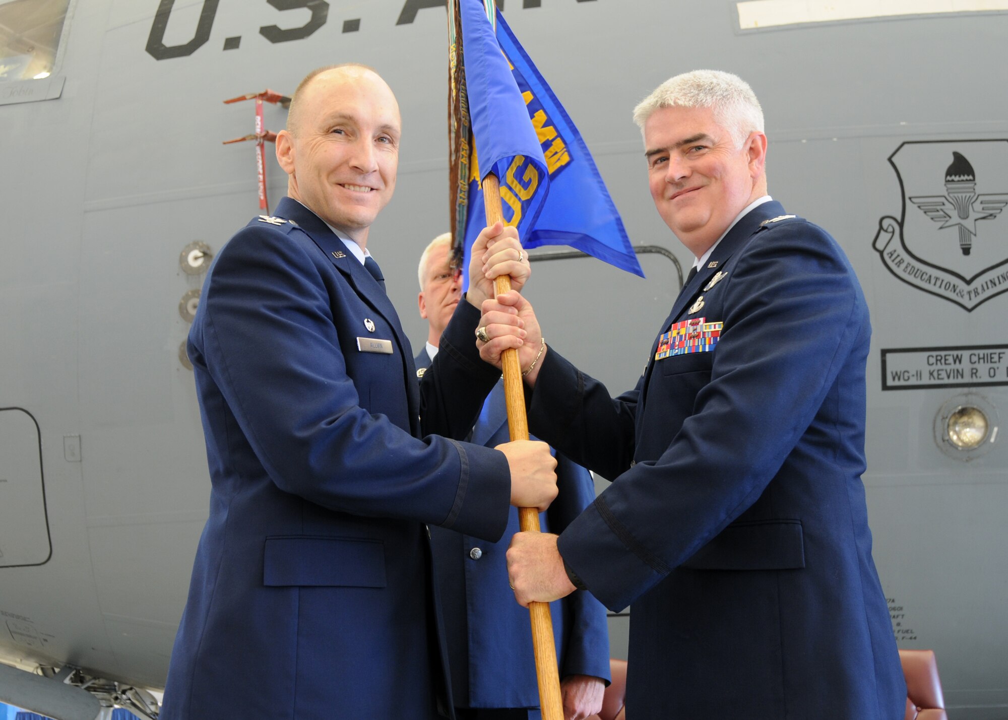 ALTUS AIR FORCE BASE, Okla.–Col. David W. Allvin, 97th Air Mobility Wing Commander (Left) hands the 97th Operations Group guideon to Col. John S. Oates (Right) during the change of command ceremony, June 5.  Colonel Oates is replacing Col. Keith E. Tobin as the 97th Operations Group Commander.  (U.S. Air Force photo/Senior Airman Jennifer L. Flores)