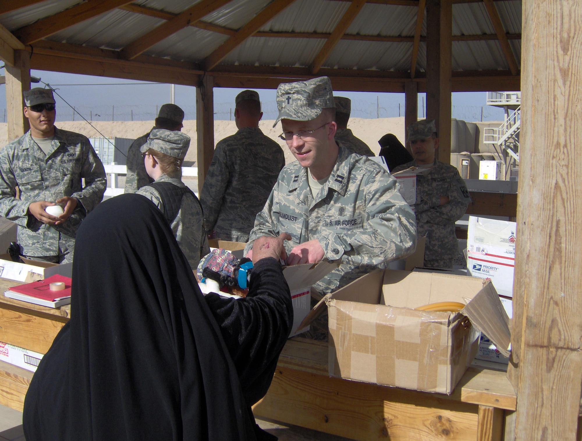 CAMP BUCCA, Iraq -- Chaplain (Capt.) Rolf Holmquist, 887th Expeditionary Secruity Forces Squadron chaplain, hands out care packages to Iraqi visitors. The chaplains office has given more than $180,000 worth of toys and hygiene products to more than 62,000 visitors in six months as part of the detainee visitation program. (U.S. Air Force photo by Staff Sgt. Jahn Espino)
