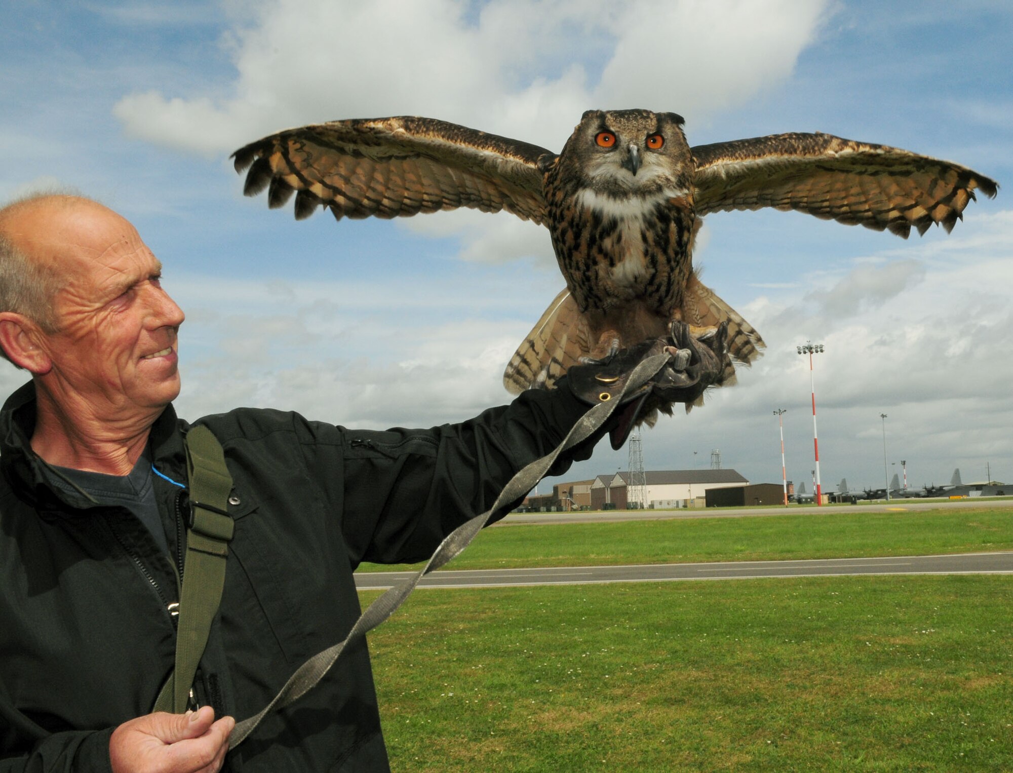 Keith Mutton, owner of Phoenix Bird Control, holds Twinkle, an Eagle owl, one of the many birds of prey he owns. Mr. Mutton and his employees are responsible for bird control on RAF Mildenhall and RAF Lakenheath. Twinkle weighs just 7 pounds, but has a wing span of 5 feet, and very large, sharp claws. She mainly works at RAF Lakenheath at night, scaring away birds such as Lapwings that try to roost on the runways. (U.S. Air Force photo by Karen Abeyasekere)