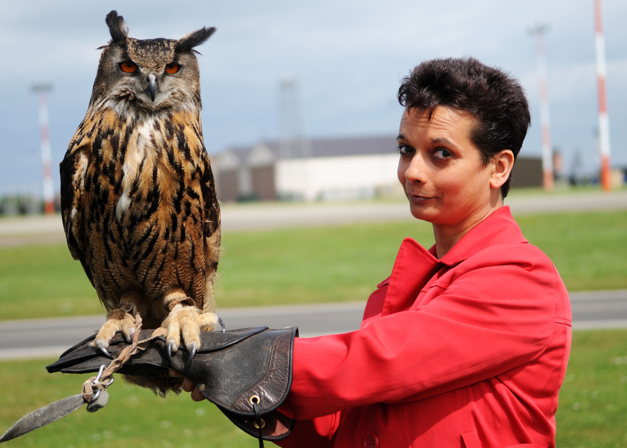 Karen Abeyasekere (right), 100th Air Refueling Wing Public Affairs, cautiously holds Twinkle, an Eagle owl, when she recently spent an afternoon with Phoenix Bird Control. Betweem them, the Phoenix employees own many different birds of prey, including owls, various falcons and hawks. The birds are used to scare away flocks of birds, such as crows and starlings, keeping RF Mildenhall's flightline clear and helping prevent birdstrikes. (U.S. Air Force photo by Staff Sgt. Jerry Fleshman)