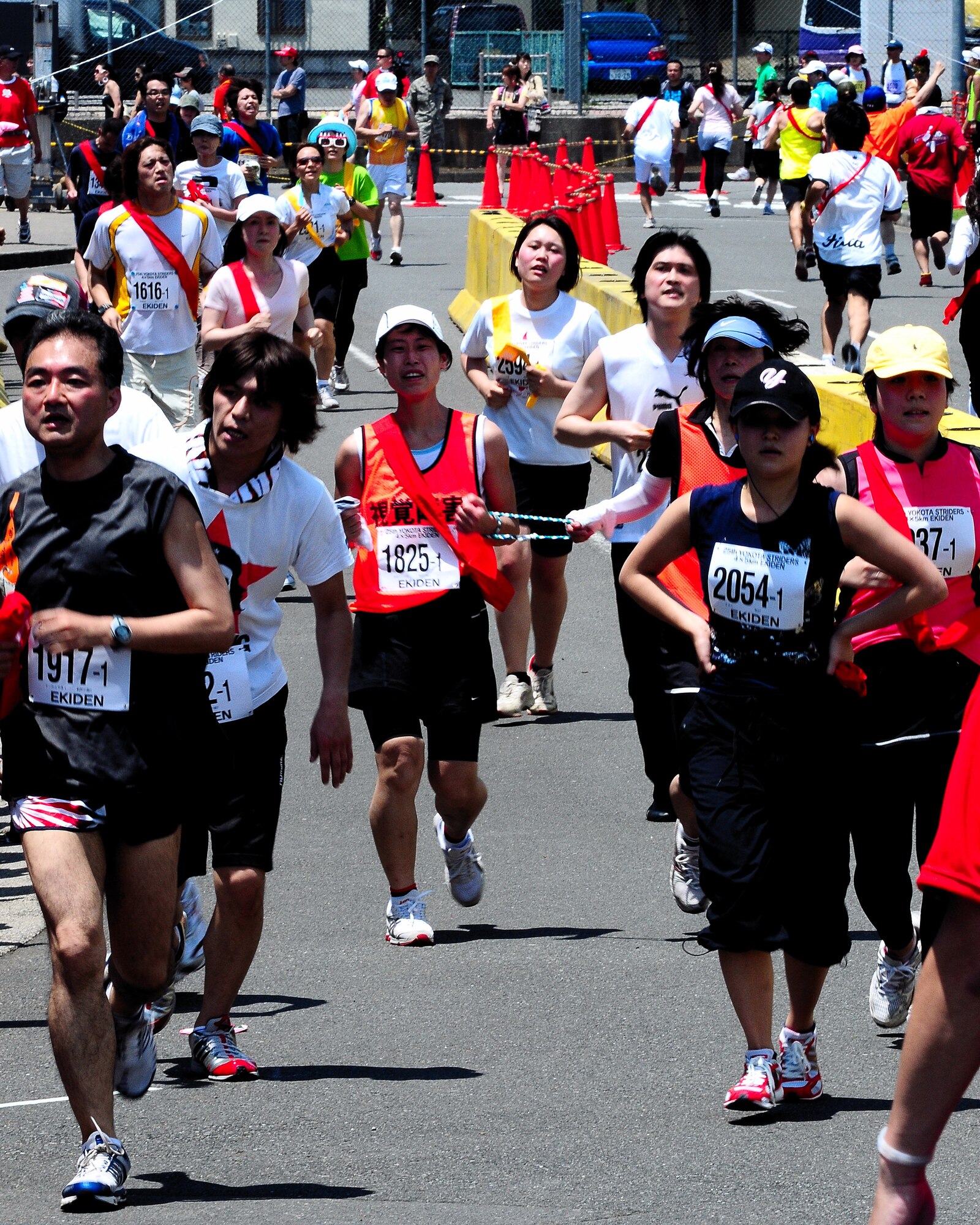 YOKOTA AIR BASE, Japan -- Runners finish their leg in the 5Kx4 relay race during the 25th Annual Yokota Striders Ekiden, June 7. The 5Kx4 race was one of three races held that day. More than 9,800 people attended the event this year. (Air Force photo/Airman 1st Class Michael Dillon)