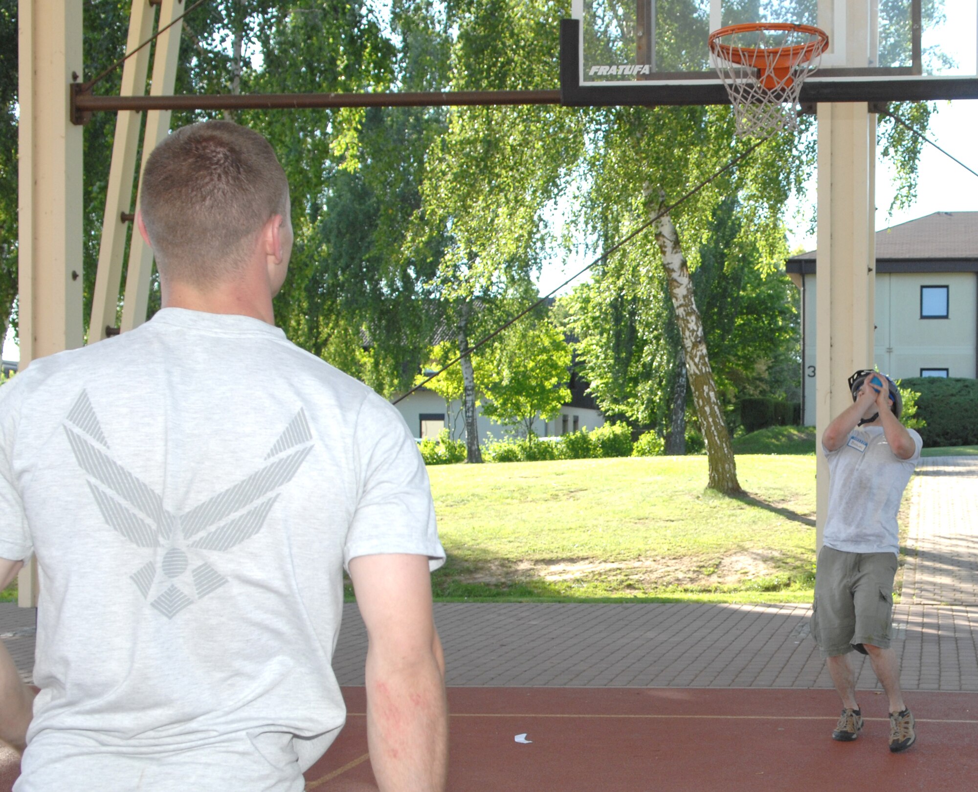 SPANGDAHLEM AIR BASE, GERMANY – Senior Airman Patrick O’Brien, 52nd Logistics Readiness Squadron, catches a water balloon after it was thrown through a basketball hoop by his teammate, Airman First Class Adam Jenkins, also of the 52nd LRS, during the 52nd LRS Amazing Race May 29, 2009. The water balloon throw was one of seven stations in the race, which was sponsored by the spouses group.  Eight teams participated in the challenging LRS event.  (U.S. Air Force photo by Master Sgt. Bill Gomez) 