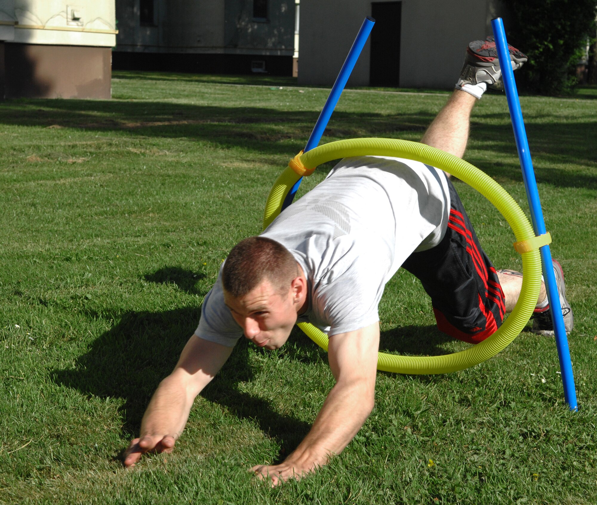 SPANGDAHLEM AIR BASE, GERMANY – Airman 1st Class Adam Jenkins, 52nd Logistics Readiness Squadron, dives through a hoop in an obstacle course during the 52nd LRS Amazing Race May 29, 2009. The obstacle course was one of seven stations in the race, which was sponsored by the spouses group.  Eight teams participated in the challenging LRS event.  (U.S. Air Force photo by Master Sgt. Bill Gomez) 
