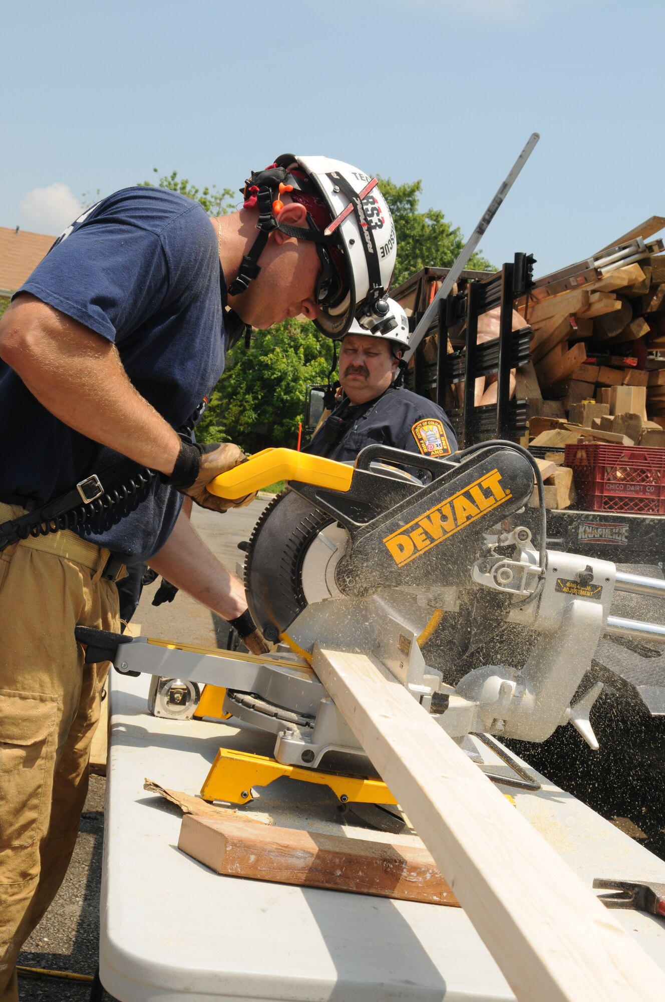 A firefighter cuts wood to support a collapsed floor during a collapse-and-rescue exercise June 8 on Bolling Air Force Base. The scheduled demolition of a section of base housing created prime location and opportunity June 1 - 12 for a joint training effort between the Naval District of Washington Fire Department and the District of Columbia Fire Department. (U.S. Air Force photo by Senior Airman Marleah Miller)