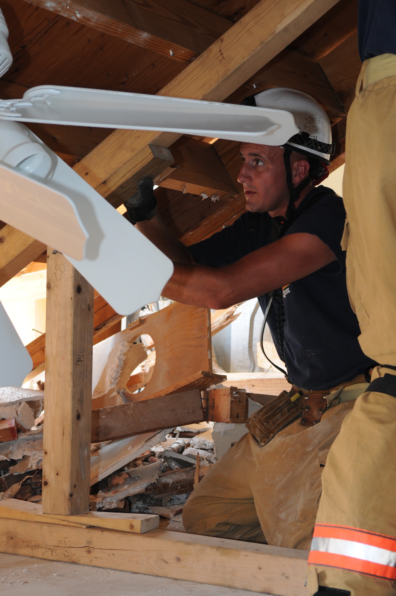 Michael Rabaiotti, District of Columbia Fire Department Rescue Squad 3, secures a slope shore to the collapsed floor during a collapse-and-rescue exercise June 8 on Bolling Air Force Base. In the process of privatizing base housing, the coming demolition of Hickam Village housing created a prime location and opportunity June 1 - 12 for the joint training effort. (U.S. Air Force photo by Senior Airman Marleah Miller) 