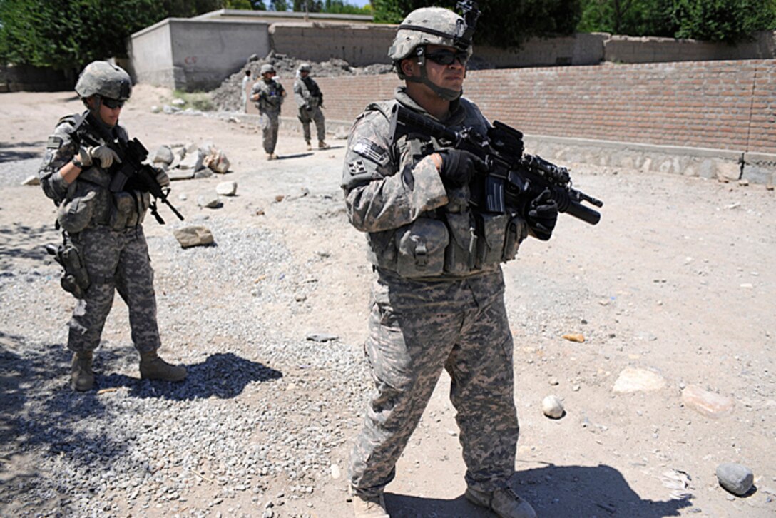 U.S. Army Spc. Ruben Nunez, right, patrols a street during an inspection operation in Nangarhar province, Afghanistan, May 30, 2009. Nunez is assigned to the Nangarhar Provincial Reconstruction Team, which is responsible for development and reconstruction projects in the province. Local residents and contractors build the projects to improve the lives of the people living in the area.