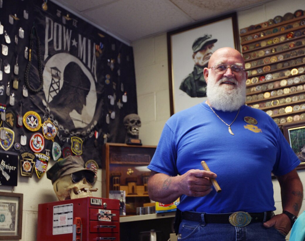 Jack Tagmeyer, the manager of the Auto Body Hobby Shop, poses in front of his office's display of various awards he recieved throughout his 24 years of active service and his continuing service with Marine Corps Community Services June 10. The shop is known for its friendly atmosphere and willingness to help Marines and sailors with any type of car body issue.