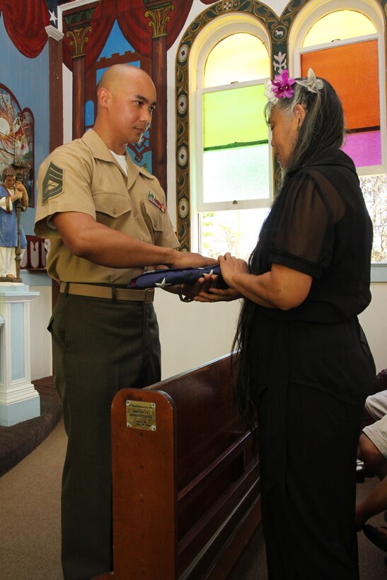 Gunnery Sgt. Arsenio Cortez presents the colors to Stephanie Lewis June 11 at the Star of the Sea Church, during funeral services for retired Lt. Col. Jack Lewis. Lewis died May 24 in his home after a battle with lung cancer. Lewis is survived by his wife Stephanie Lewis, five children and eight grandchildren.::r::::n::Cortez is the Marine Corps Base Hawaii Public Affairs chief. Stephanie and Jack married a month before his death.::r::::n::