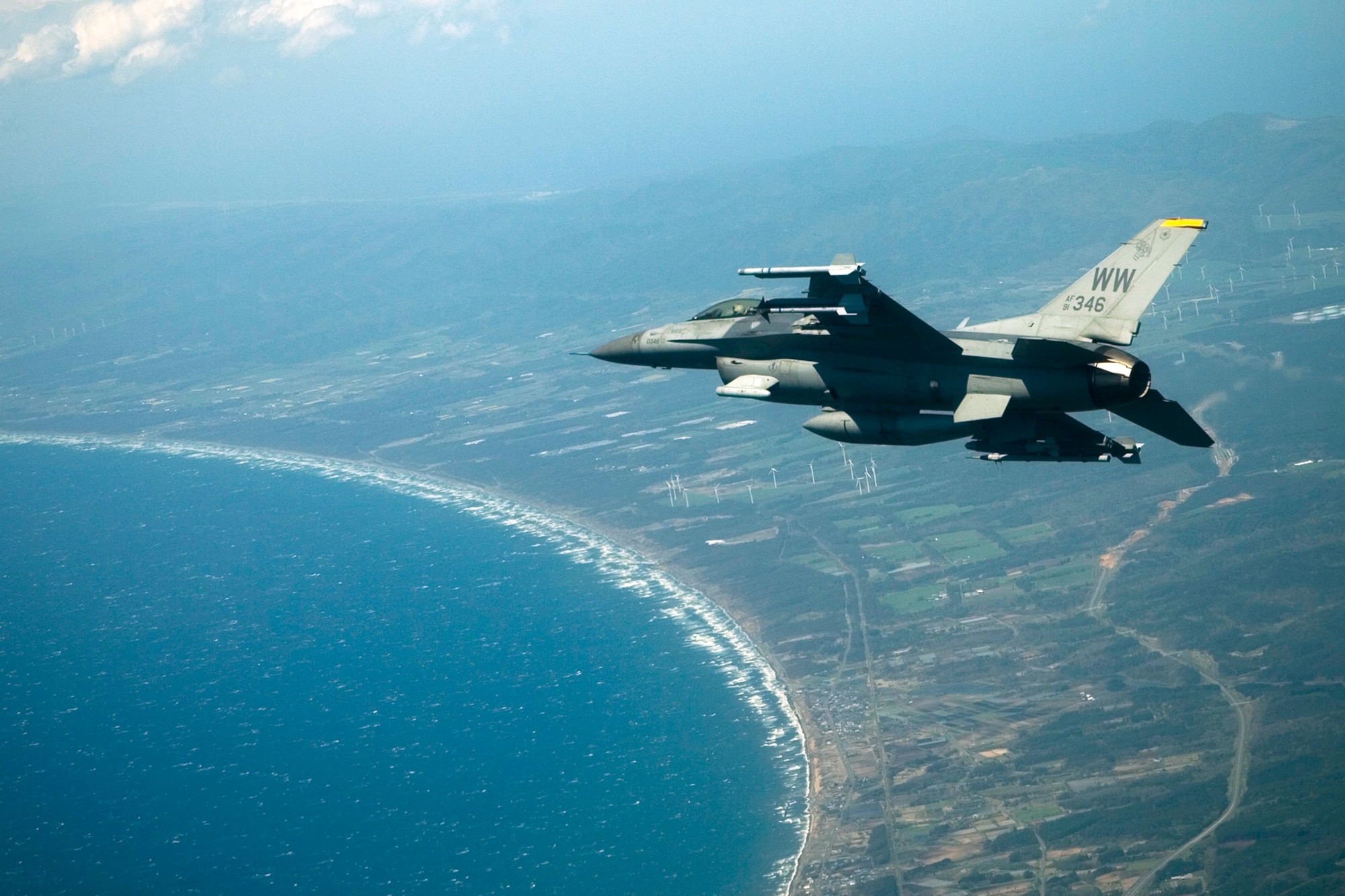 MISAWA AIR BASE, Japan -- An F-16 Fighting Falcon flies over Misawa and Lake Ogawara on the way to a training mission May 13, 2009. The plane is loaded with an inert GBU-38 that was successfully dropped on Draughon Range, marking a first for Misawa Air Base. (U.S. Air Force photo by 1st Lt. Ryan Cross)