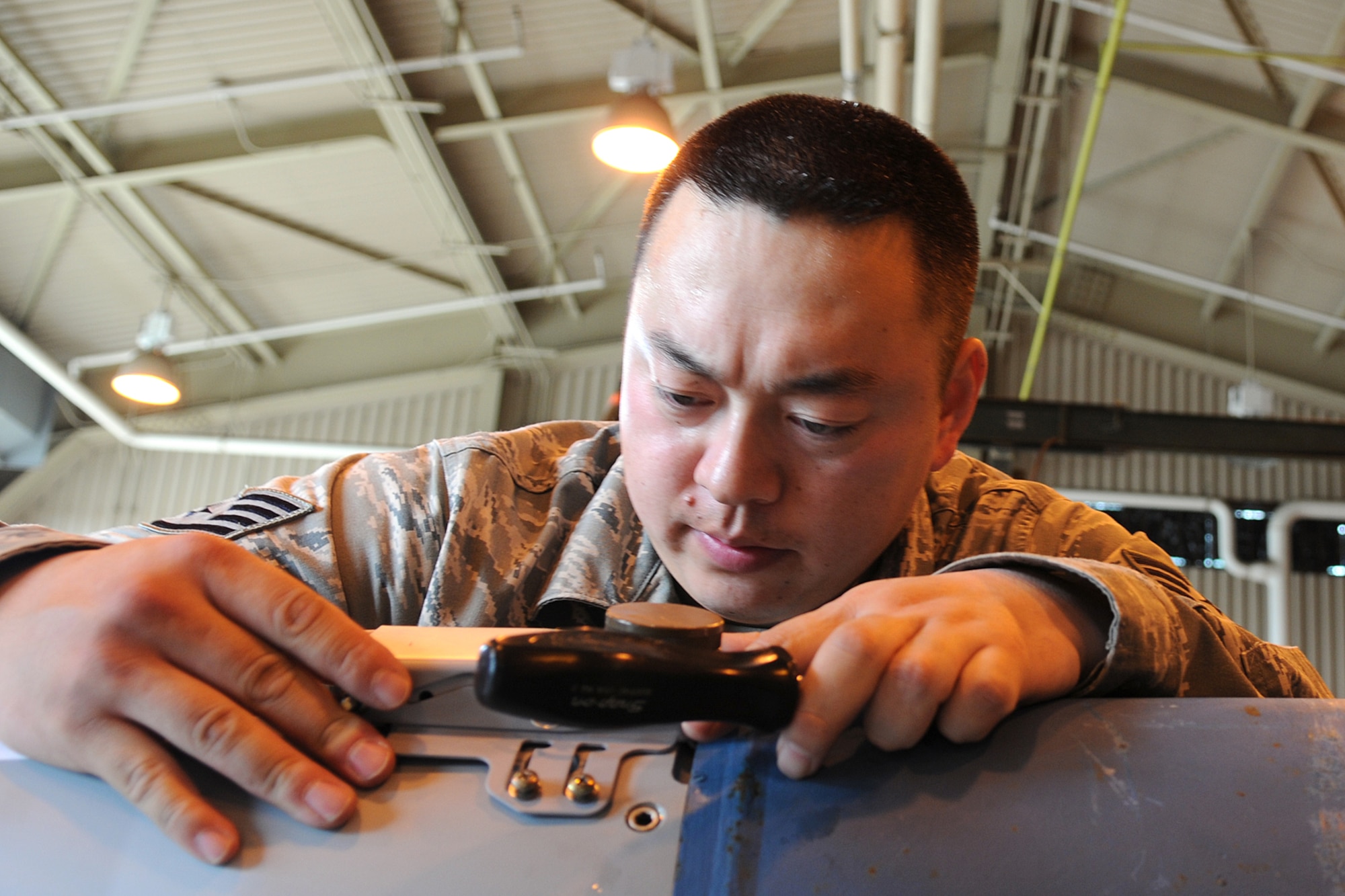 MISAWA AIR BASE, Japan -- Staff Sgt. James Davis, 35th Maintenance Squadron munitions flight crew member, repositions the umbilical connector on a GBU-38 June 9, 2009. The umbilical connector serves as an interface between the bomb and pilot, allowing the pilot to change fuse settings while in flight. Sergeant Davis is a native of Del Rio, Texas. (U.S. Air Force photo by Staff Sgt. Rachel Martinez)