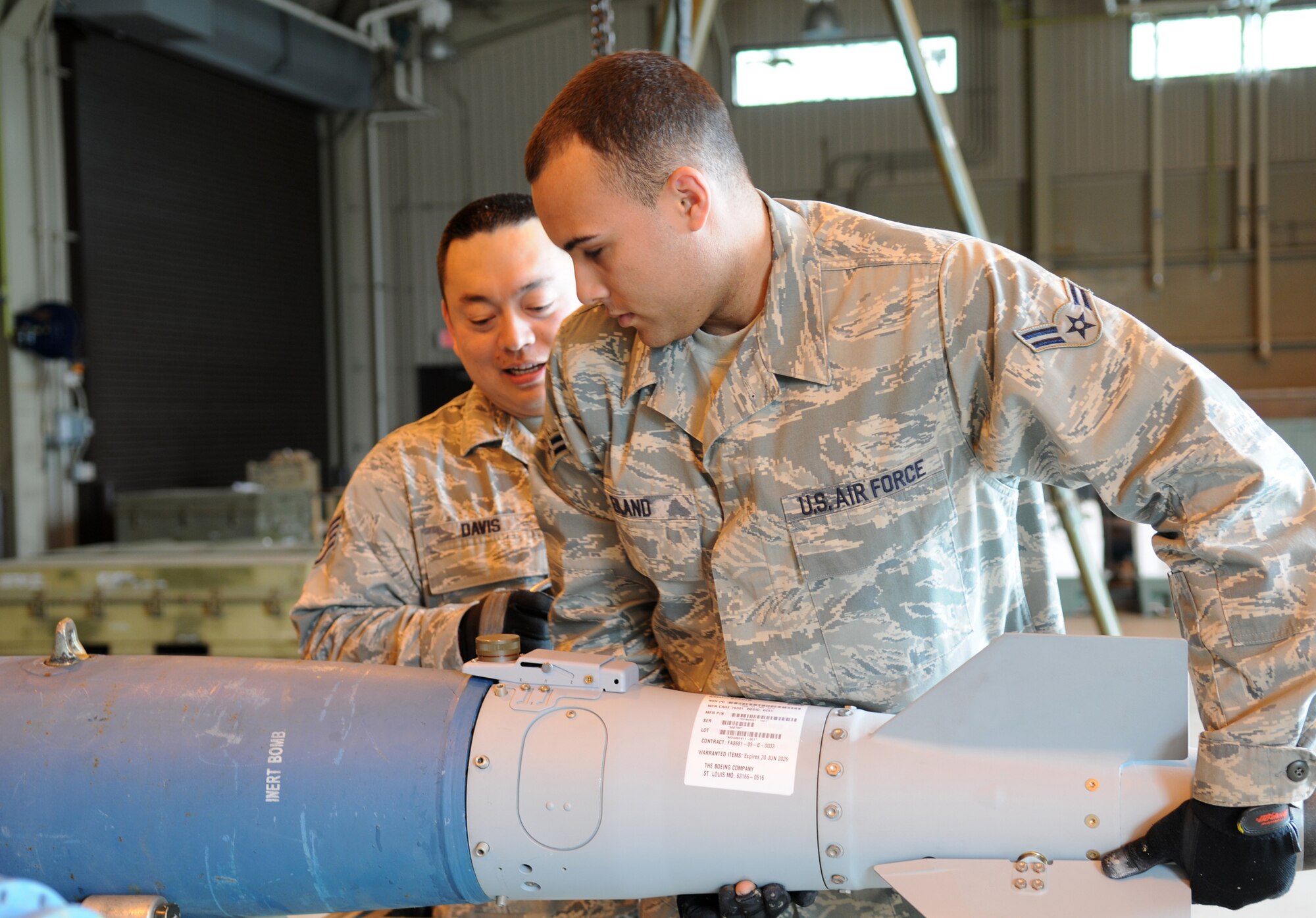 MISAWA AIR BASE, Japan -- Airman 1st Class Michael Eiland and Staff Sgt. James Davis, both from the 35th Maintenance Squadron munitions flight, attach a fin assembly to a GBU-38 body June 9, 2009. The fin contains a guidance system with GPS that allows for more precise targeting. (U.S. Air Force photo by Staff Sgt. Rachel Martinez)