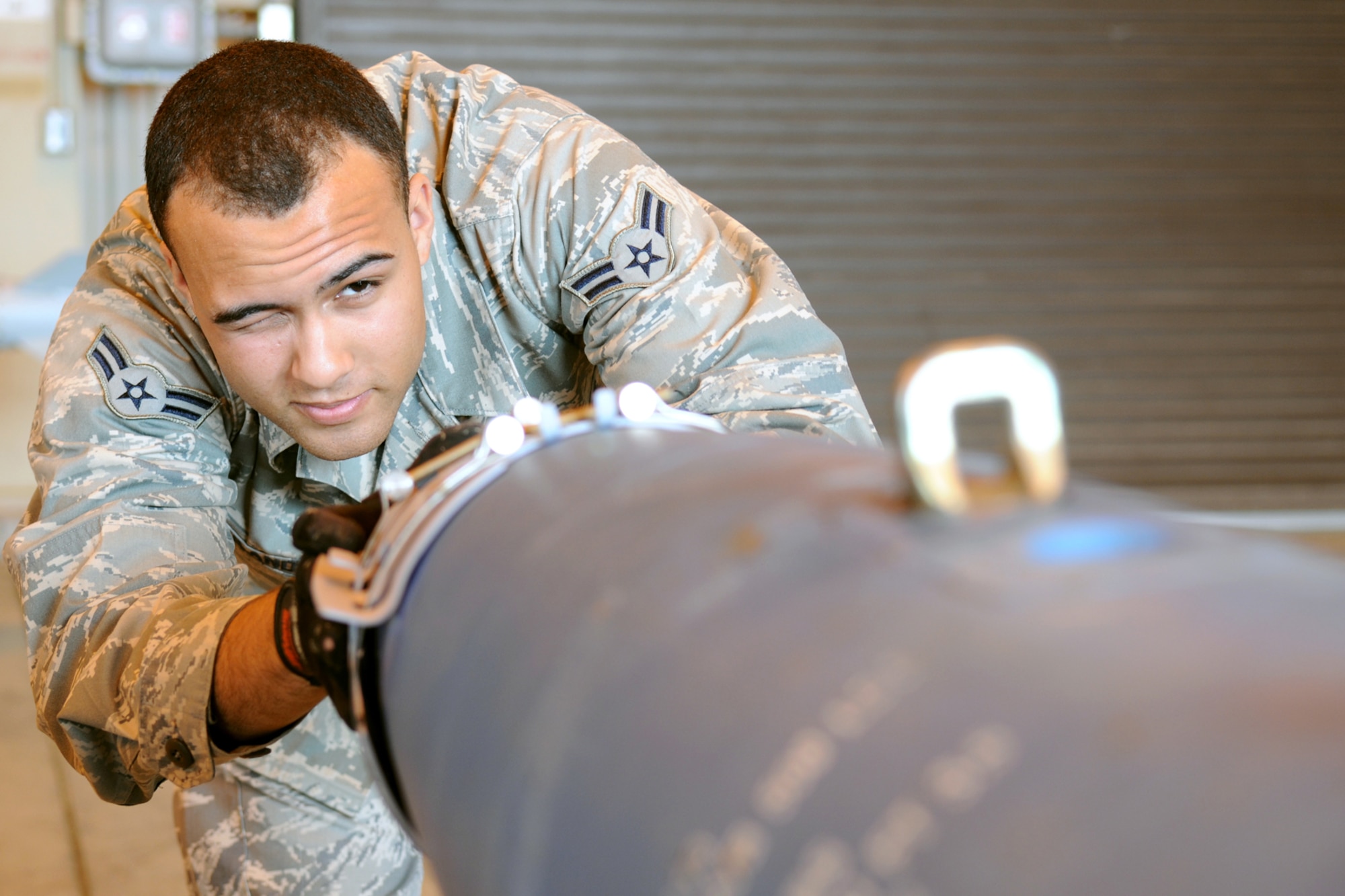 MISAWA AIR BASE, Japan -- Airman 1st Class Michael Eiland, 35th Maintenance Squadron munitions journeyman, aligns the strake assembly with suspension lugs on a GBU-38 June 9, 2009. The munitions flight builds approximately six training assets a year, but while deployed Airman Eiland, a native of Omaha, Neb., built up to 30 munitions in one day. (U.S. Air Force photo by Staff Sgt. Rachel Martinez)