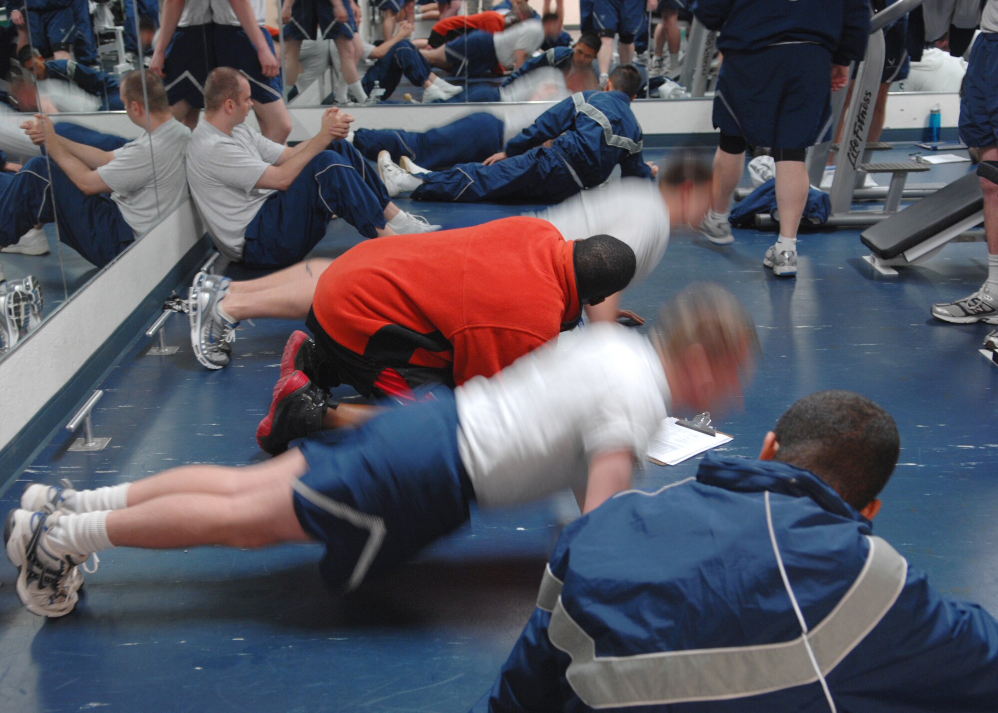 Airmen do the push-up portion of their physical training test May 29, 2009, Eielson Air Force Base, Alaska. A fitness testing specialist watches each Airman ensure they perform each push-up correctly. Airmen can visit the Health and Wellness Center throughout the week to visit with a specialist and make sure they are practicing the correct form for their PT test.