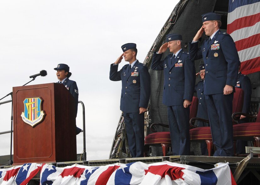 During the 60th Operations Group change of command June 1st 2009 at Travis Air Force Base, left to right, Staff Sergeant Janina Morrison , member of the 21st Airlift Squadron sings the national anthem while Colonel Mark Dillon, 60th Air Mobility Wing commander, Colonel Jim Baron, outgoing 60th Operations Group commander and Colonel Anthony Butters, incoming 60th Operations Group commander, render honors to the flag. (U.S. Air Force photo by Civ/Nan Wylie)