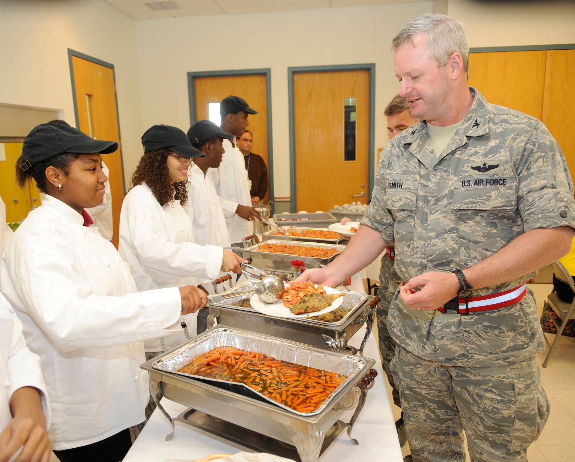 Tempest Lewis, left, Jessica Anderson, Christopher Burnett and Reggie Paris from the Culinary Arts Department at Pemberton High School serve food to Col. Scott Smith,  305th Air Mobility Commander and other Joint Base McGuire-Dix-Lakehurst, N.J., wing leaders at a luncheon at the base chapel on June 1. (U.S. Air Force photo/Carlos Cintron)