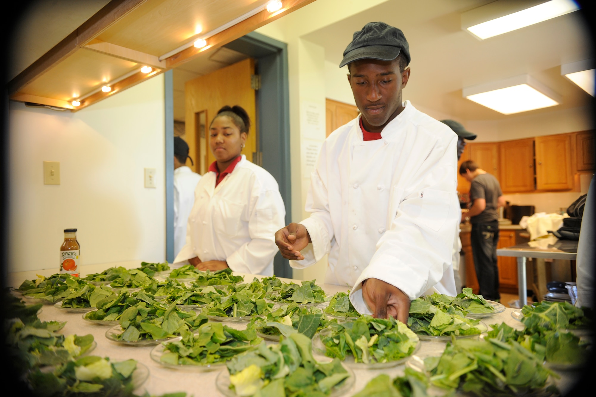 From left, Tempest Lewis, age 16, and Christopher Burnett, age 18, from the Culinary Arts Department at Pemberton High School prepare salads for the 305th Air Mobility Wing Commanders' Luncheon held at the Joint Base McGuire-Dix-Lakehurst, N.J.,  chapel on June 1. (U.S. Air Force photo/Carlos Cintron)
