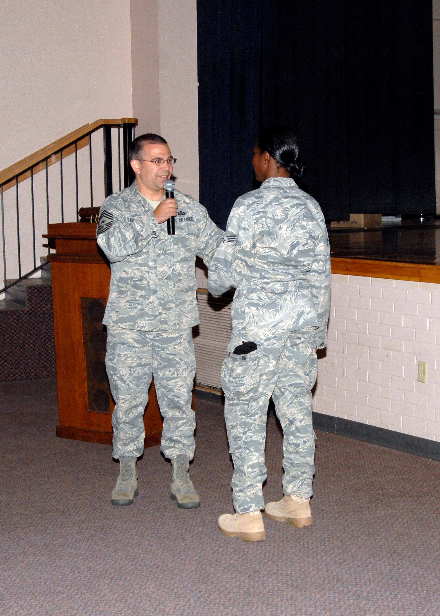 Command Chief Master Sgt. Timothy Horn, 22nd Air Refueling Wing command chief, recognizes Senior Airman Karlia Brown, 22nd Security Force, during the enlisted call at the base theater, June 3. 2009, McConnell Air Force Base, Kan.  Airman Brown was presented a coin because of her attention to detail by finding critical errors on a fellow team members uniform. (Photo by Senior Airman Anthony Mejia
