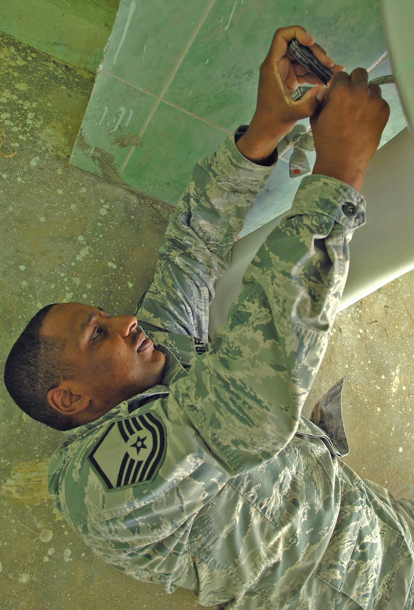 In a building adjacent to the Sultan Saqi Shrine here, Master Sgt. Todd McGee, 506th Expeditionary Civil Engineer Squadron plumber, tightens a section of a pipe under a bathroom sink. Sergeant McGee upgraded the building's water system, and repaired commodes and sinks in this building as a part of partnership with Iraqi airmen to restore two structures located in the Sultan Saqi cemetery. (U.S. Air Force photo/Senior Airman Jessica Lockoski)