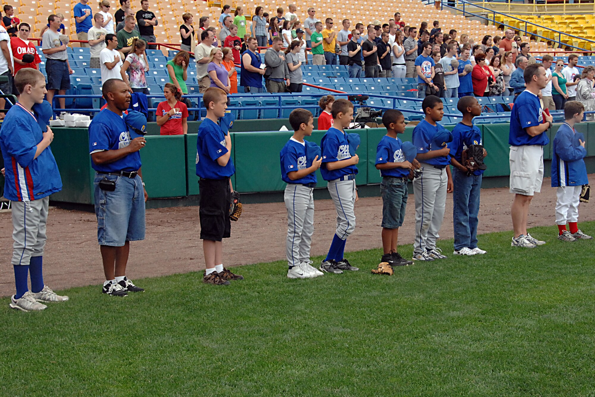 OFFUTT AIR FORCE BASE, Neb. -- Members of the Offutt Lightning baseball team as well members of the Offutt and Omaha community stand during the singing of the national anthem at the Omaha Royals Military Appreciation Game at Rosenblatt Stadium June 7. The team was a part of pre-game ceremonies. U.S. Air Force photo by Kendra Williams