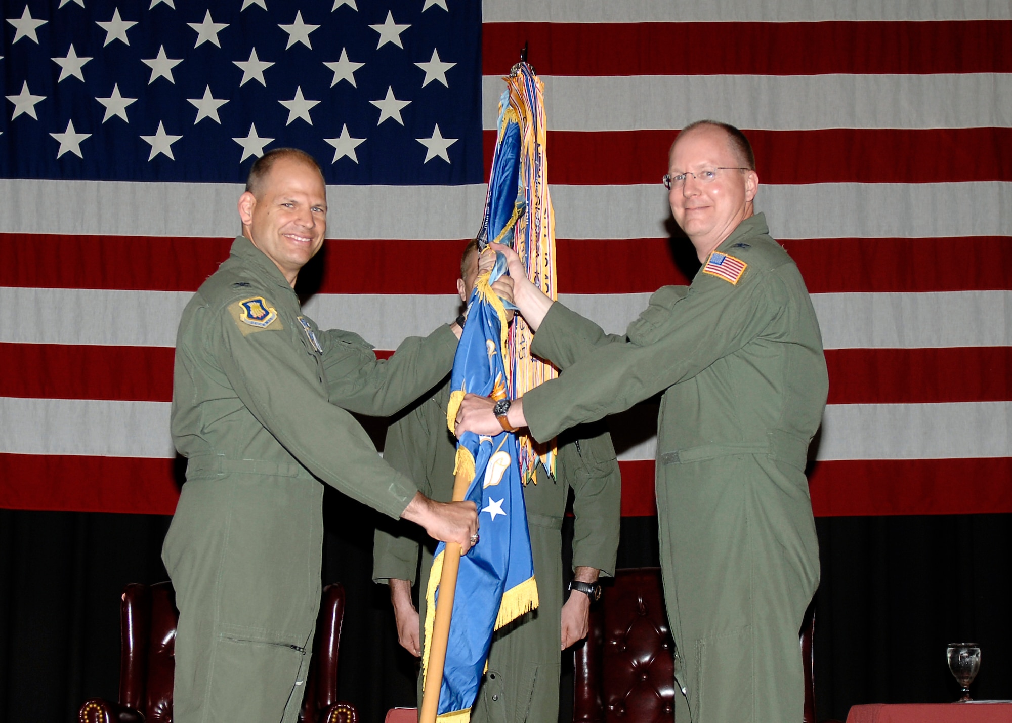 MCCONNELL AIR FORCE BASE, Kan. -- Col. James C. Vechery, 22nd Air Refueling Wing commander, hands the guidon to Col. Billy Langford, gaining 22nd Operations Group commander, during the Operations Group change of command ceremony at the Robert J. Dole Community Center ballroom, June 5. Col. Langford takes the guidon to symbolize taking command of the organization. (Photo by Senior Airman Anthony Mejia)