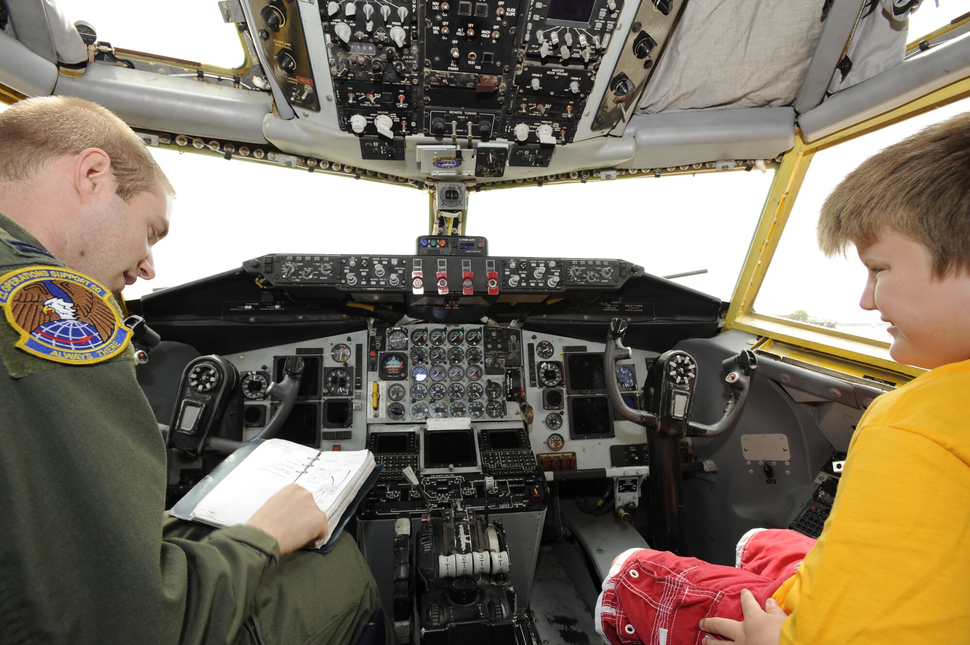 MCCONNELL AIR FORCE BASE, Kan. -- Capt. Chad Gugas, 22nd Operations Squadron, talks about the importance of following a pre-flight checklist with Logan, 11, a student from the Heartspring Community of Autism Resources and Education camp. Four students from the camp interviewed Team McConnell members about the refueling mission. (Photo by Tech. Sgt Chyrece Campbell)
