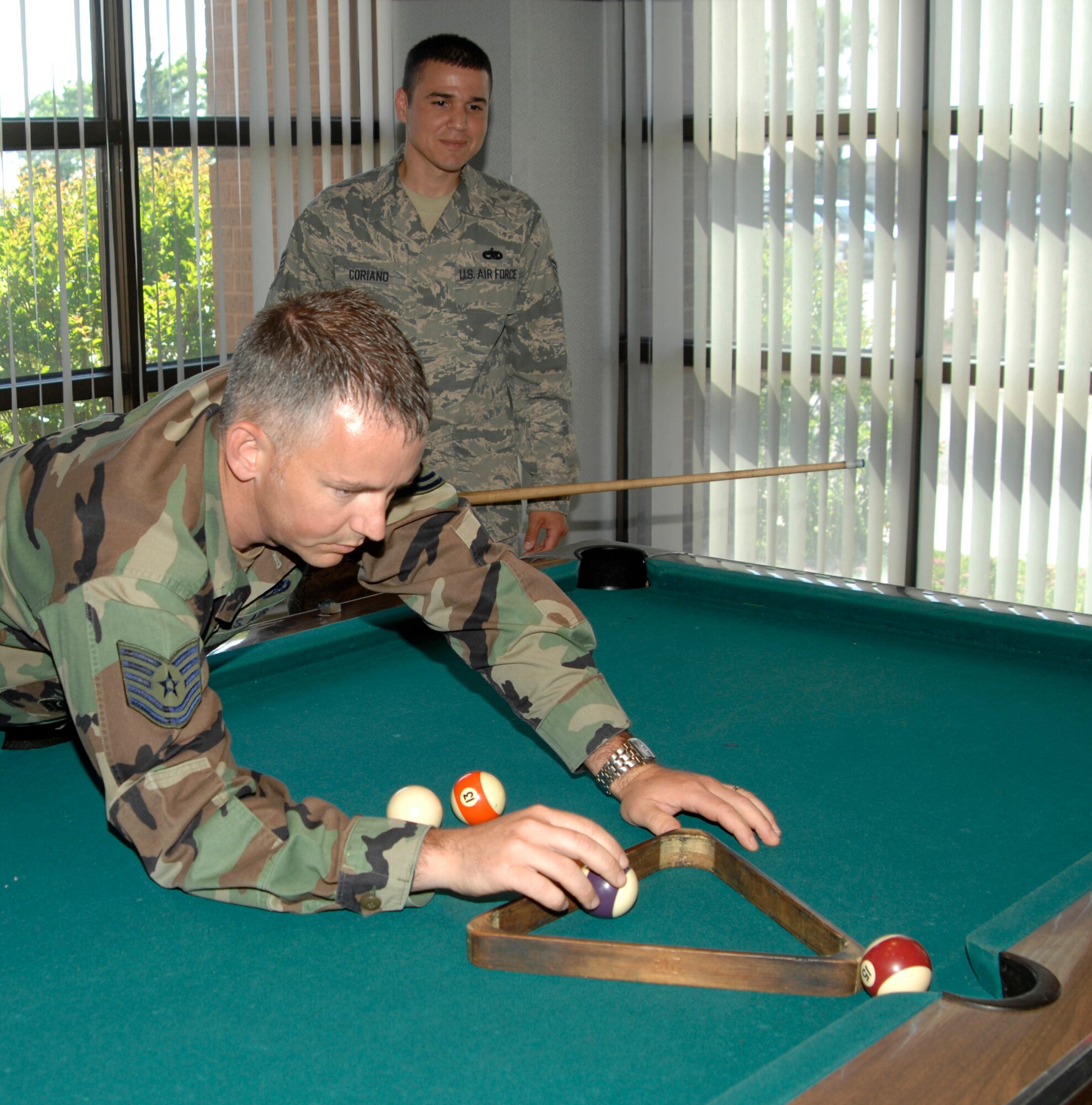 MCCONNELL AIR FORCE BASE, Kan. -- Tech. Sgt. James Noel, 22nd Force Support Squadron, teaches Staff Sgt. Braulio Coriano, 22nd Force Support Squadron, a few tricks on the pool table during Boss and Buddy at the Storm Cellar, June 5. Sergeant Noel served as an Airmen Leadership School instructor for more than four years and will be returning to work in the maintenance squadron again. Sergeant Coriano will take over as an ALS instructor. (Photo by Senior Airman Laura Suttles)