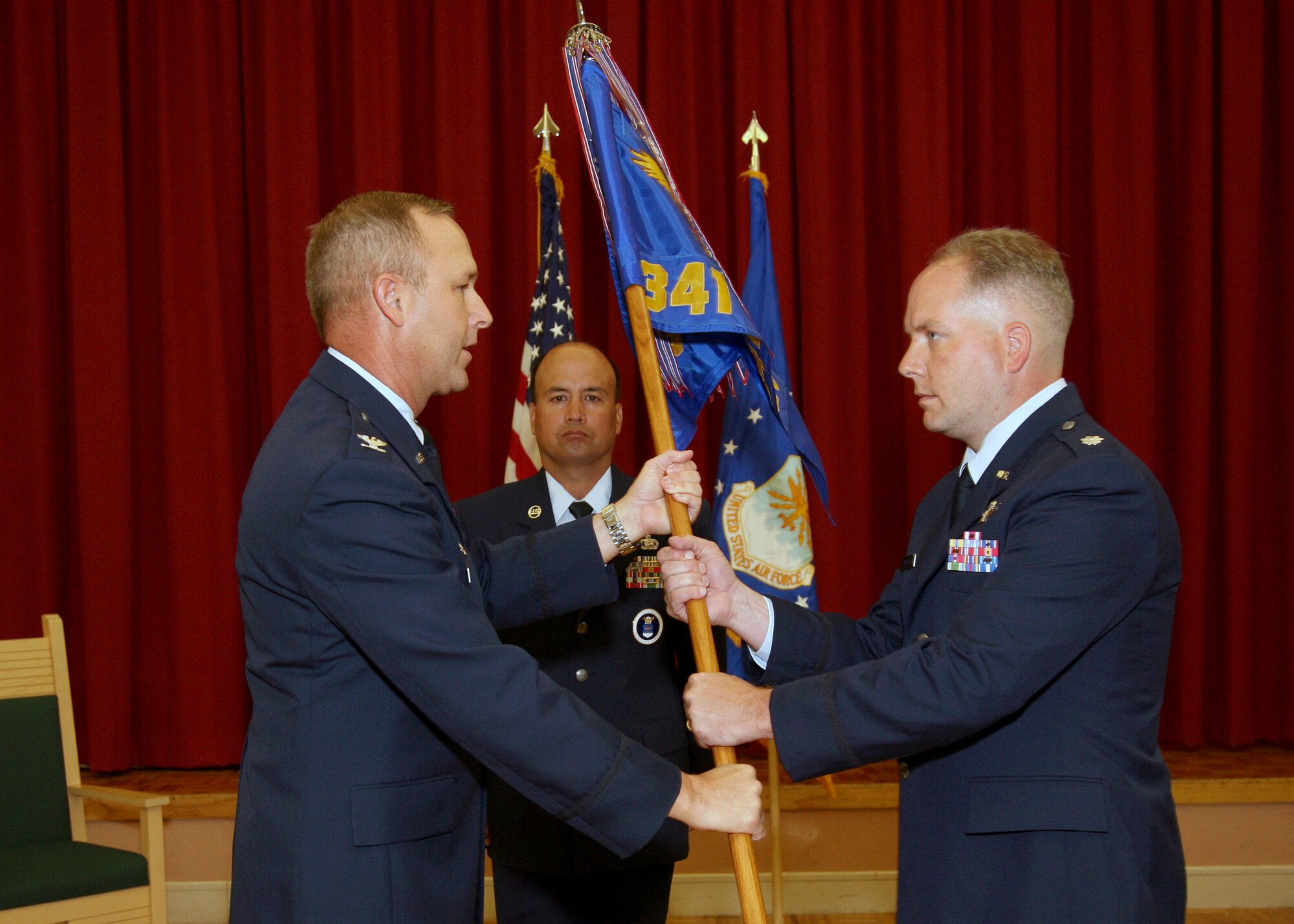 Lt. Col. Eric Johnson, right, accepts the guidon as new commander of the 341st Recruiting Squadron from Col. Michael Brice during a May 27 ceremony at Lackland Air Force Base, Texas. Master Sgt. Thomas Deering served as the flag bearer. Colonel Brice is the 369th Recruiting Group commander and Sergeant Deering is the squadron’s first sergeant. Colonel Johnson replaced Col. John Poast as commander. The 341st RCS consists of 11 flights and 102 people across two states in the southwestern United States, covering 125,000 square miles. (U.S. Air Force photo)