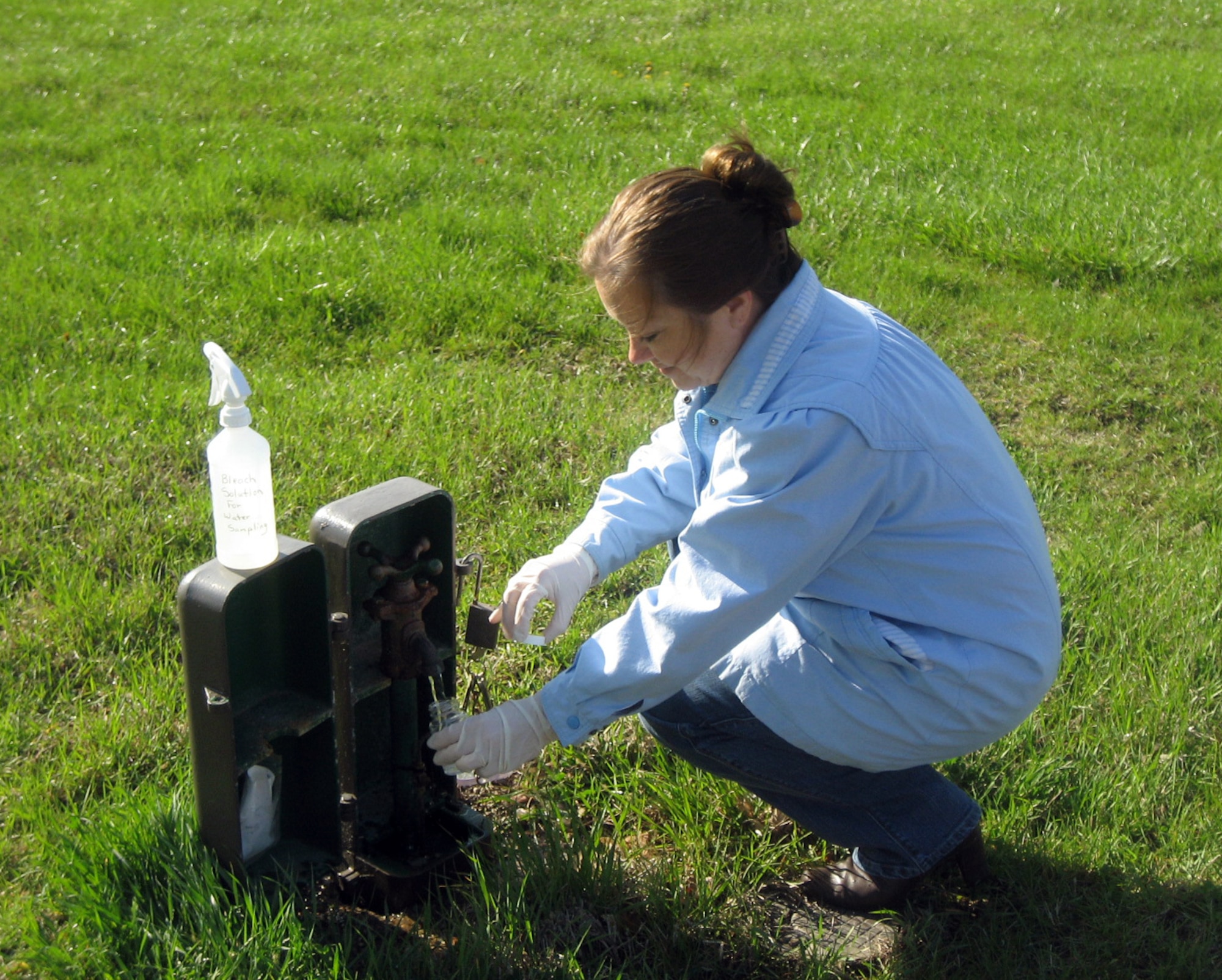 Kim McSparran, Bioenvironmental Engineering's Drinking Water Program manager with the 88th Medical Group, collects a sample of drinking water from a tap at Wright-Patterson Air Force Base.  Weekly testing for bacteria is just one of many activities base environmental management and bioenvironmental engineering officials do to ensure the quality of water on base. The annual base drinking water quality report is available on line at www.wpafb.af.mil/units/cev/. (U.S. Air Force photo/1st Lt. Brian Shuler)