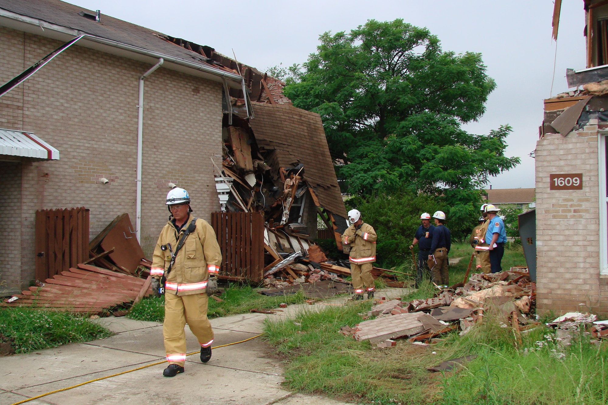 Naval District of Washington Fire Department and District of Columbia Fire Department firefighters survey the area during a collapse-and-rescue training exercise June 4 on Bolling Air Force Base. As part of training, firefighters must first survey the area to establish what type of collapse they’re facing, where the victim’s location and if the area is safe. Once secure, a rescue action plan is developed. (U.S. Navy photo by Battalion Chief Michael Tenaglia, NDWFD)