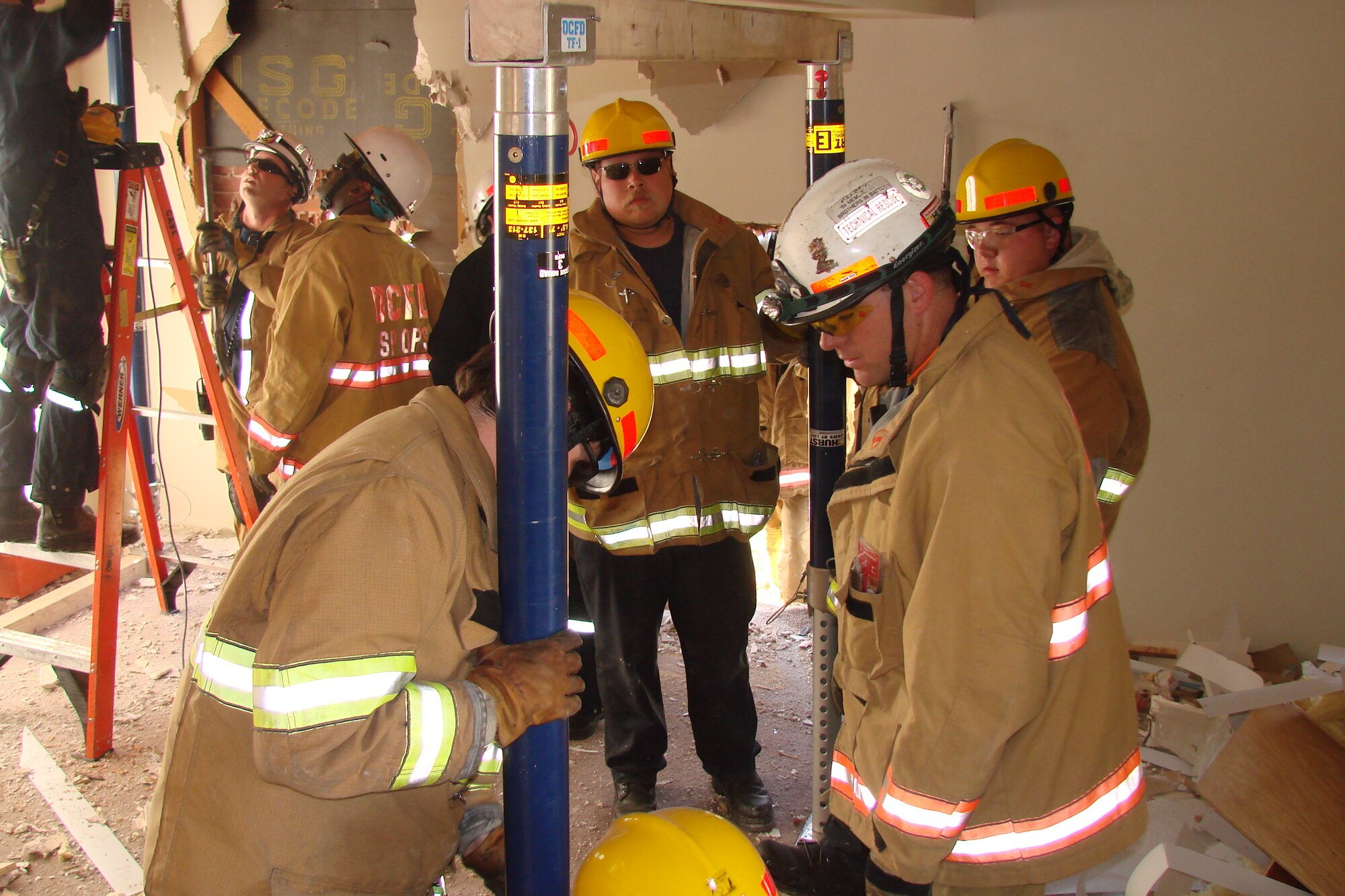Naval District of Washington Fire Department and District of Columbia Fire Department firefighters receive training on proper placement of stands in an unstable building June 1 on Bolling Air Force Base. The impending demolition of Hickam Village housing created a prime location and opportunity June 1 - 12 for a joint training effort between the two departments. (U.S. Navy photo by Battalion Chief Michael Tenaglia, NDWFD)