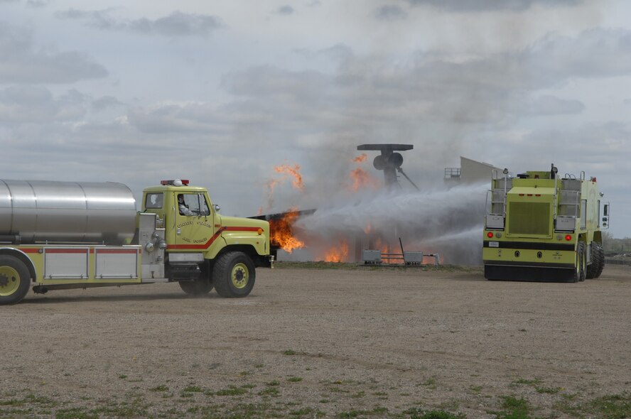 MINOT AIR FORCE BASE, ND – Members from the 5th Civil Engineer Squadron’s Fire Department extinguishes the flames on a simulated crashed plane during a major accident response exercise (MARE) here, June 5.  The exercise was held to further strengthen the base’s ability to respond to an aerial accident, in preparation for the upcoming air show and open house, Northern Neighbors Day, scheduled for July 18 here.  (U.S. Air Force photo by Staff Sgt. Angel Gallardo)