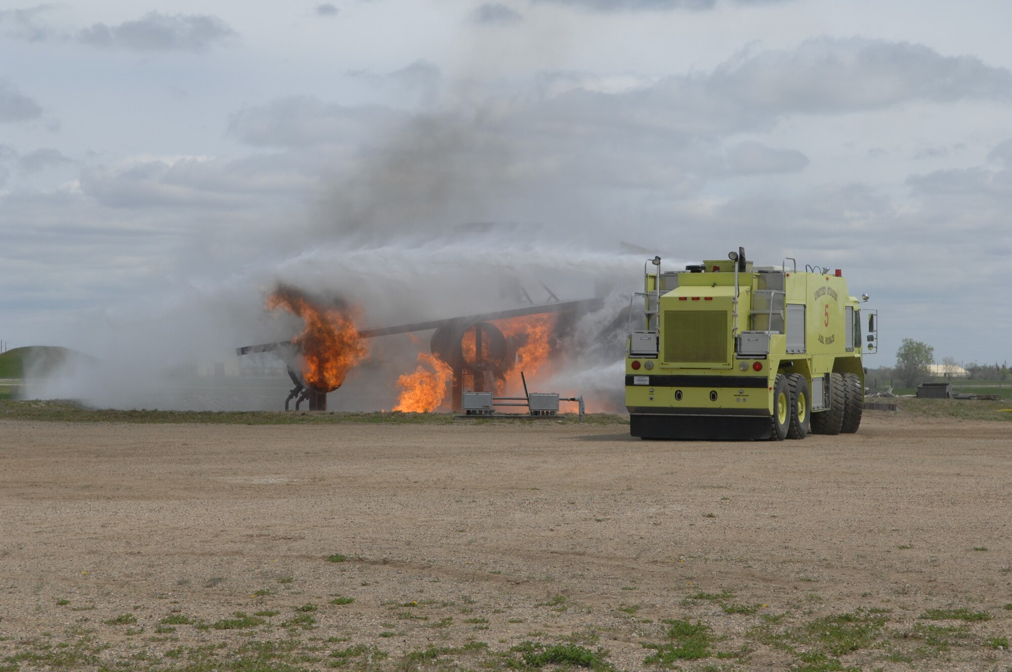 MINOT AIR FORCE BASE, ND – Members from the 5th Civil Engineer Squadron’s Fire Department extinguishes the flames on a simulated crashed plane during a major accident response exercise (MARE) here, June 5.  The exercise was held to further strengthen the base’s ability to respond to an aerial accident, in preparation for the upcoming air show and open house, Northern Neighbors Day, scheduled for July 18 here. (U.S. Air Force photo by Staff Sgt. Angel Gallardo)