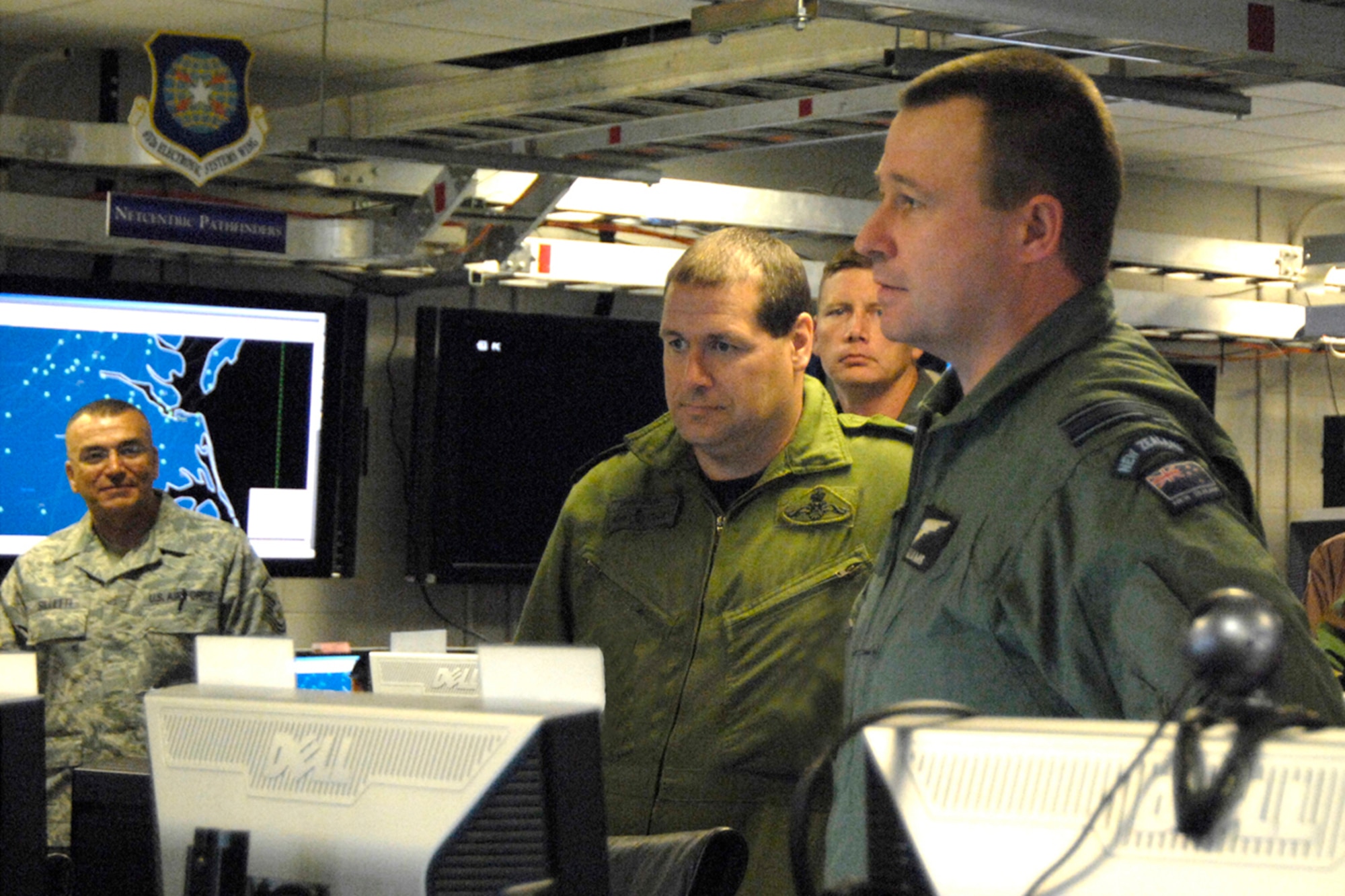 Hanscom Air Force Base, Mass.  -- Coalition Warrior Interoperability Demonstration participants (from left) Air Force Reserve Master Sgt. Domenic Silletti, Canadian Air Force Capt. David Finlay, Mass. Air National Guard Lt. Col. Vaughn Littlejohn and New Zealand Air Force Maj. Dai Williams go over preliminary information here June 10.  Total Force Airmen will join coalition partners and civil agency officials for the 11-day demonstration that kicks off June 15 at Hanscom and other sites around the world.  (USAF Photo by Mark Herlihy.)
