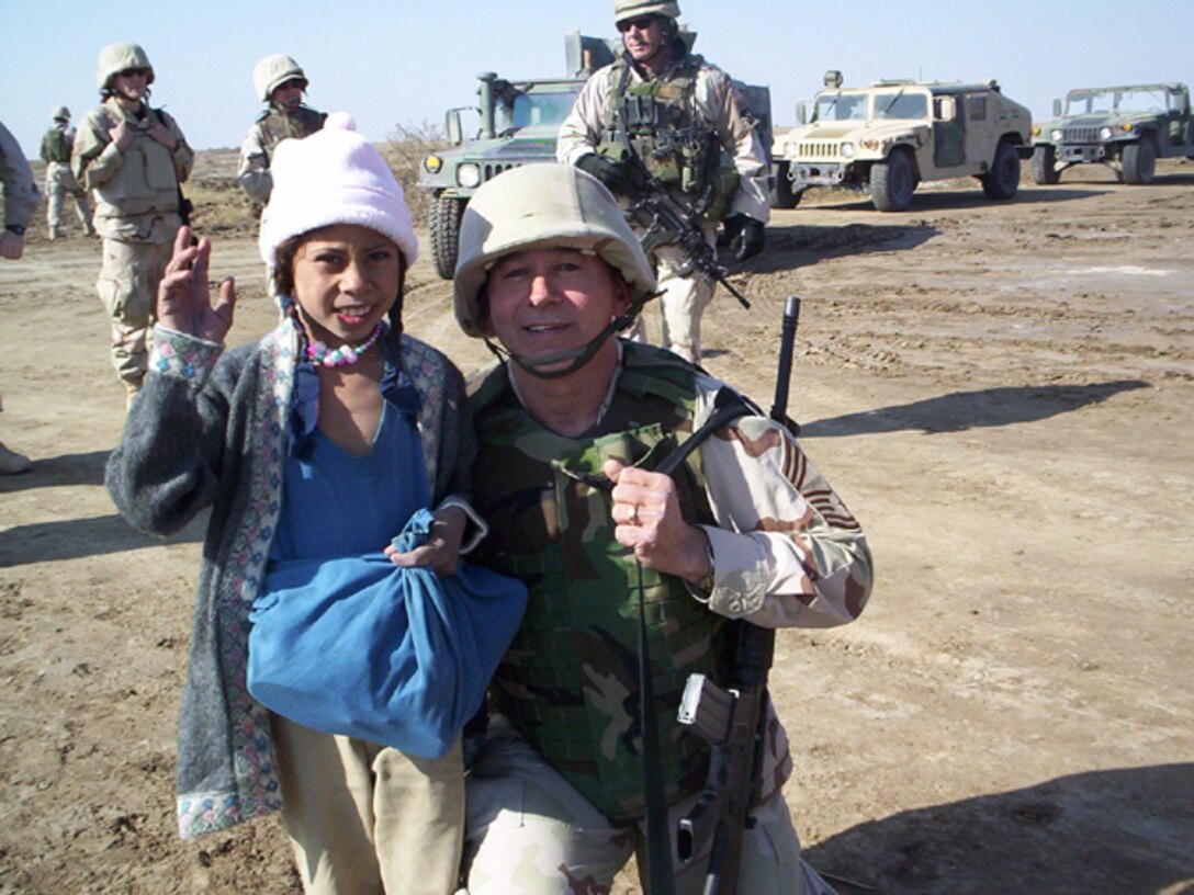 Chief Master Sgt. Jason A. Anderson of the 119th Wing Logistical Squadron takes a moment to talk to a young girl while serving on a deployment overseas.
