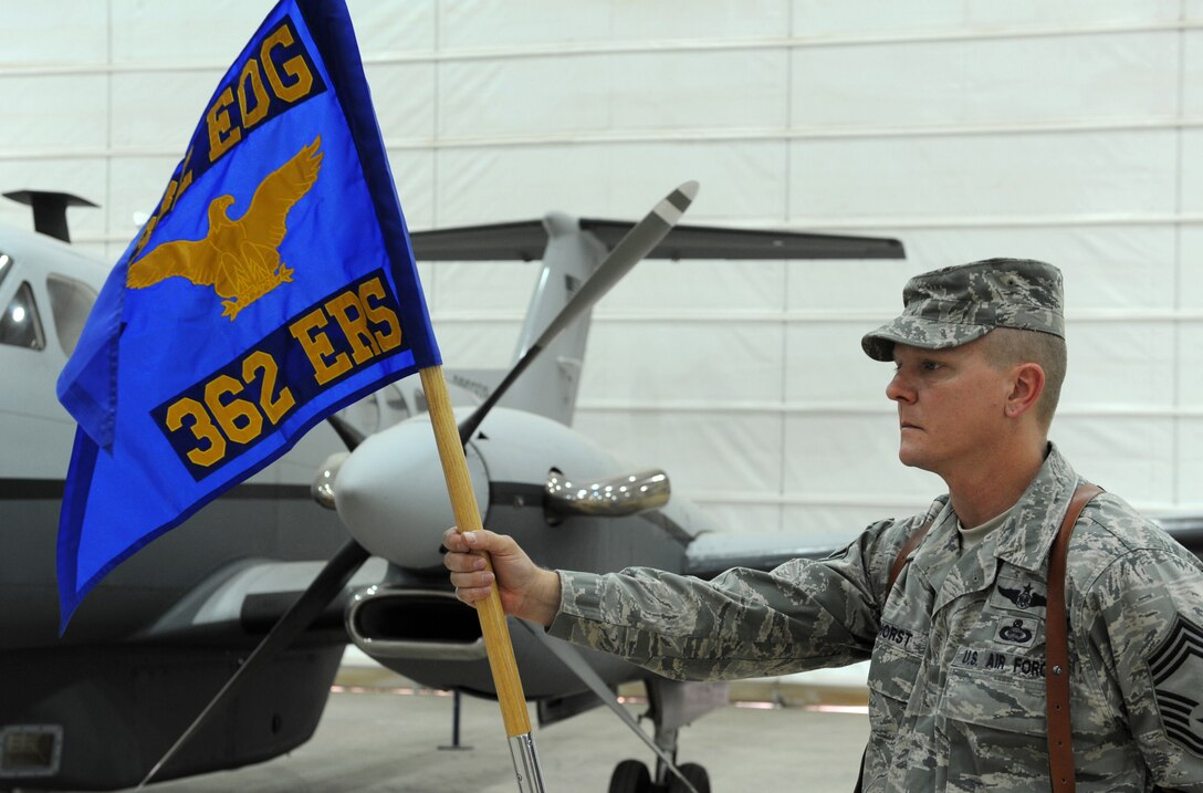 JOINT BASE BALAD, Iraq ? Chief Master Sgt. Christopher Barhorst, 362nd Expeditionary Reconnaissance Squadron chief enlisted manager, holds the unit guide-on during an assumption of command ceremony here June 9. The ceremony was held to activate the 362nd ERS; the new unit conducts MC-12 operations. The MC-12 is a medium-altitude manned special-mission turboprop aircraft designed for intelligence, surveillance and reconnaissance. MC-12 aircraft will operate from here in support of Coalition and joint ground forces. Native of Sidney, Ohio, Chief Barhorst is deployed here from Hurlburt Field, Fla. (U.S. Air Force photo/Senior Airman Tiffany Trojca)