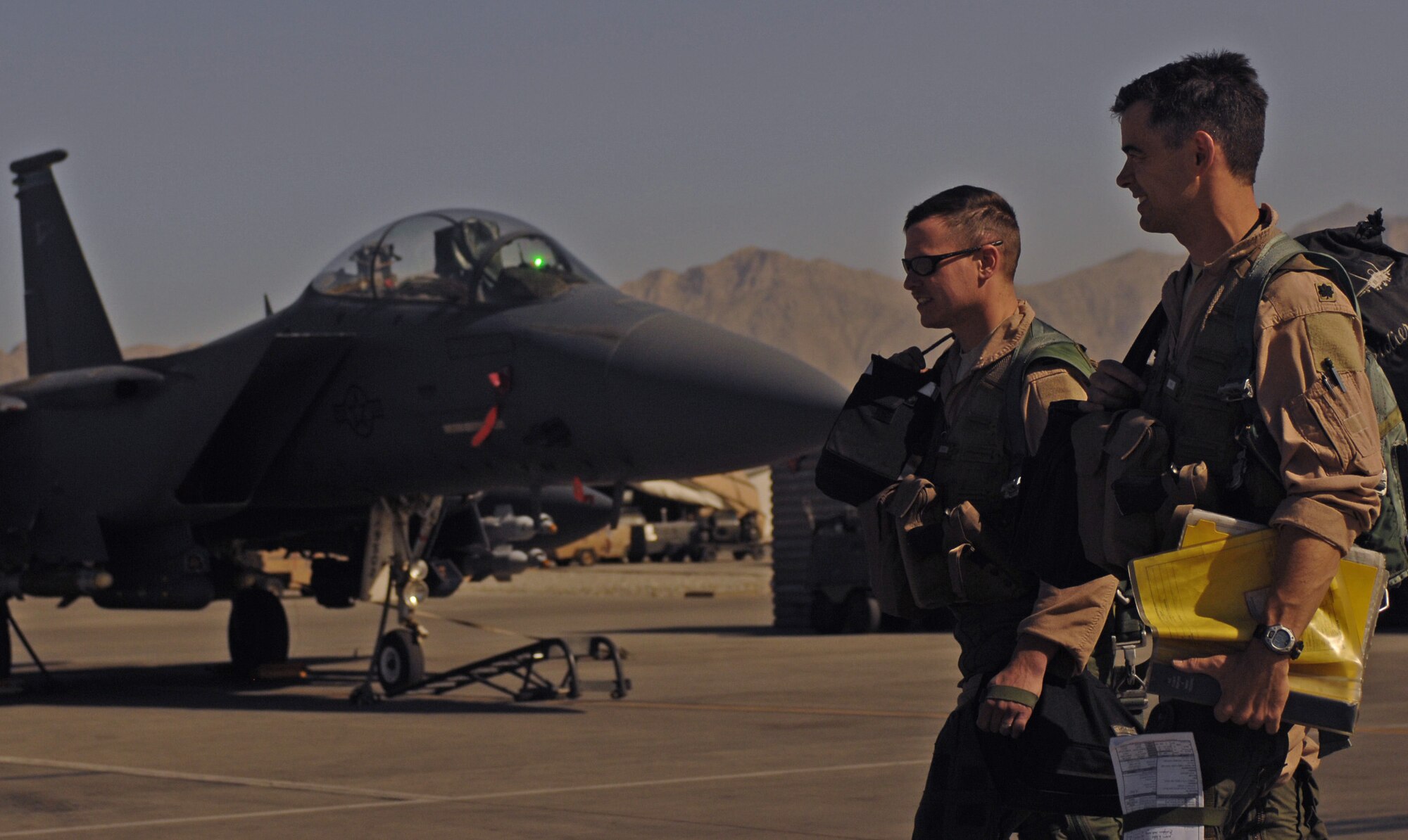 BAGRAM AIR FIELD, Afghanistan - Lt. Col. Christopher Didier, F-15 pilot, and Capt. Thomas Veilleux, weapons system operator, for the 336th Expeditionary Fighter Squadron, walk back to the squadron after completing a close air support mission June 9. Last month the 336th EFS and 74th Expeditionary Fighter Squadron  together logged a total of more than 5,000 combat flight hours over Afghanistan. The F-15s and A-10s assigned here provide close air support and airborne intelligence, surveillance and reconnaissance for American and coalition ground troops. (Air Force/Staff Sgt. Jason Lake)