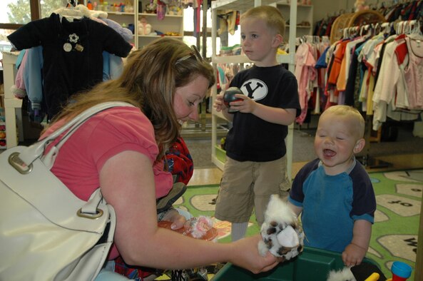 Miranda Lotz and 14-month-old Cyrus look through a bin of stuffed animals and toys as 4-year-old Mason looks on May 28 at the Airman's Attic. The facility is open to military members of all ranks and their family members, and is open Thursdays and Saturdays from 10 a.m. to 2 p.m. (U.S. Air Force photo/Senior Airman Dillon White)   