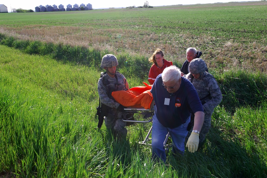 MINOT AIR FORCE BASE, ND – Members from the Carpio Emergency Management Service and 91st Missile Security Forces Squadron carry out a “victim” during a recent, joint anti-terrorism exercise near a base launch facility here, June 4.  Two simulated bombs were placed near the facility during this exercise where base personnel, Carpio officials, and the Minot Police Department responded.  The purpose of the exercise was to ensure vigilance and readiness in order to defeat possible terrorist threats wherever they may occur. (U.S. Air Force photo by Tech. Sgt. Lee A. Osberry Jr.)