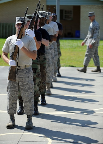 Honor guard members stand at the ready position while their instructor critiques their movements outside the Charleston AFB honor guard headquarters building at Hunley Park June 3. Honor guard members from Charleston, Shaw, McChord and Seymour Johnson AFBs participated in the Mobile Training Course June 1 to 10. (U.S. Air Force photo/Senior Airman Timothy Taylor)