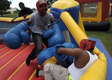 Eugene Brown knocks down Jabez Wright in an inflatable boxing ring at the picnic grounds during the Charleston AFB picnic June 5. Mr. Eugene and Mr. Jabez work for DynCorp International through the U.S. Army  (U.S. Air Force photo/Senior Airman Timothy Taylor)