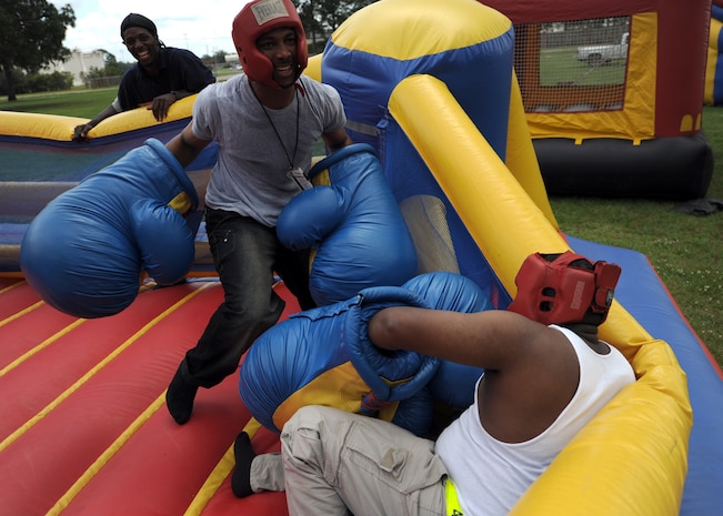 Eugene Brown knocks down Jabez Wright in an inflatable boxing ring at the picnic grounds during the Charleston AFB picnic June 5. Mr. Eugene and Mr. Jabez work for DynCorp International through the U.S. Army  (U.S. Air Force photo/Senior Airman Timothy Taylor)