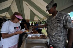 Airman 1st Class Alexander Amos serves pulled pork to a Charleston community member during the Charleston AFB picnic June 5. The picnic was the kickoff event for Air Mobility Command's MatchUP summer program, where players can win prizes by participating in base activities. Airman Amos is a material manager apprentice with the 437th Force Support Squadron. (U.S. Air Force photo/Senior Airman Timothy Taylor)