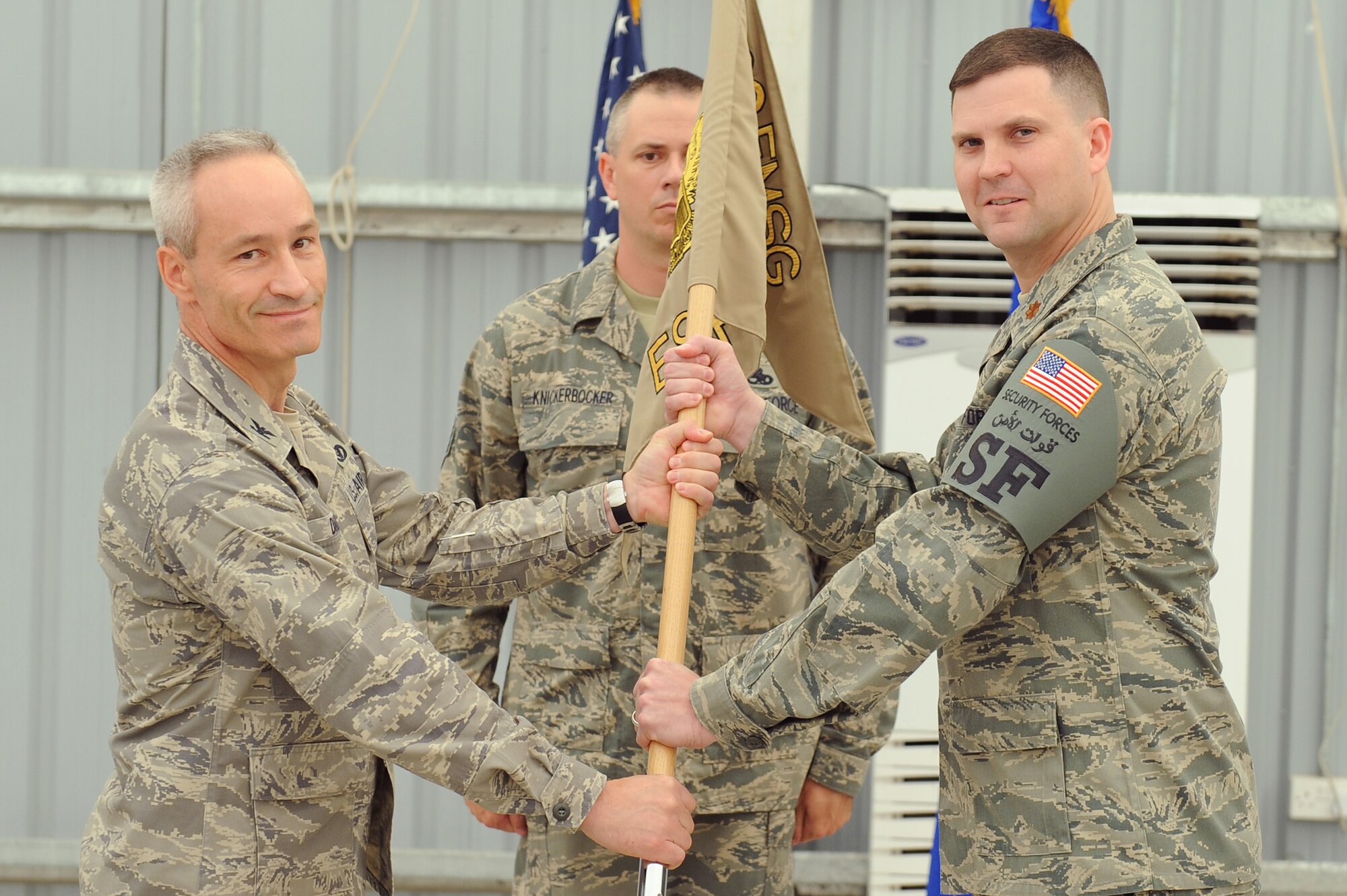 SOUTHWEST ASIA - Maj. Aaron Guill takes command of the 380th Expeditionary Security Forces Squadron as he receives the squadron flag from Col. Darren Daniels, 380th Expeditionary Mission Support Group, commander, June 9 an undisclosed location in Southwest Asia. Major Guill Roth comes from RAF Alconbury, England to lead the 380th ESFS defenders. (U.S. Air Force photo by Senior Airman Brian J. Ellis) (Released)