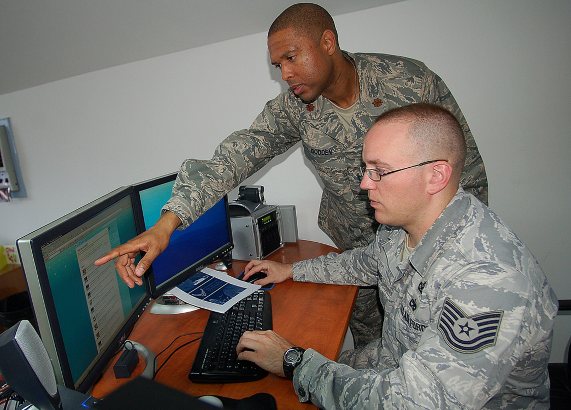 Maj. Rickardo Bodden points out the Manas Air Base, Kyrgyzstan, Twitter link to Tech. Sgt. Harry Kibbe as they make updates to the newly created site. The 376th Air Expeditionary Wing Public Affairs Office put Manas AB aboard the Twitter 'twain' in order to keep the world abroad in the know about the base's goings on. Go to www.twitter.com/manasab for the latest Manas tweets. Go to www.manas.afcent.af.mil for news, photos and videos about the Manas AB mission. (U.S. Air Force photo/Tech. Sgt. Phyllis Hanson)