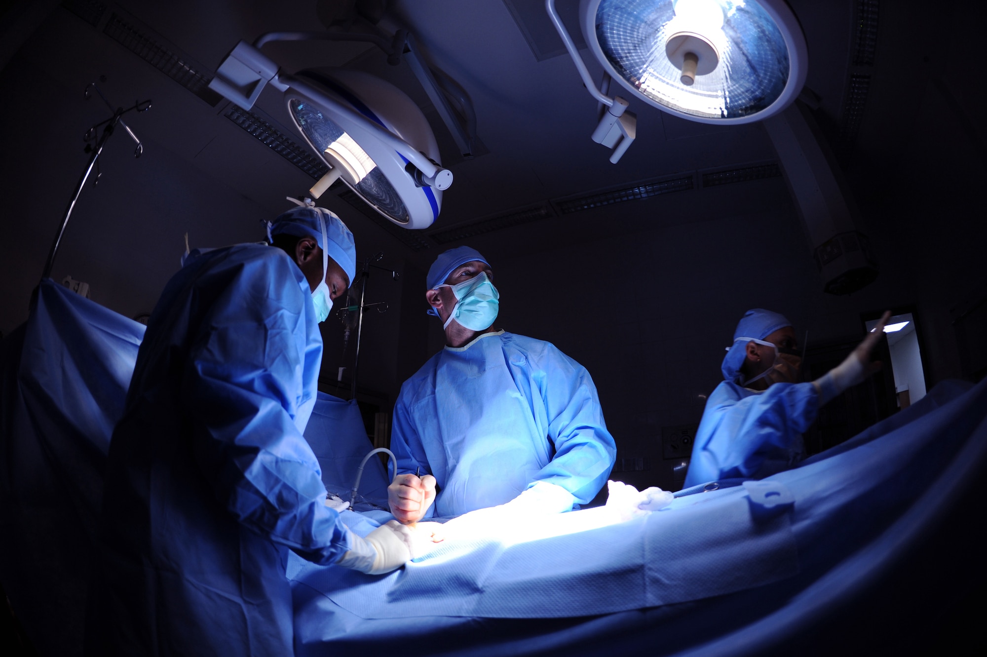 Major (Doctor) Brian Holt (middle), 379th Expeditionary Medical Group general surgeon, views a video monitor to aid him during an operation for an inguinal hernia as Staff Sgt Troy Leach (left) and Staff Sgt Vanessa Clark stand by to assist, June 5, 2009, at an undisclosed location in Southwest Asia.  This specific surgery allows the patient to return to duty quicker and with less pain.  The surgeries performed here range from elective to acute emergencies.  The surgical team provides treatment for patients coming in from all over the U.S. Central Command's Area of Responsibility.  Major Holt hails from St. Peters, Mo. and is deployed from Misawa Air Base, Japan.  Sergeant Leach hails from Nashville Tenn. and is deployed from Keesler Air Force Base, Miss.  Sergeant Clark is from Fort Lauderdale, Fla. and is also deployed from Keesler Air Force Base, Miss., all in support of Operations Iraqi and Enduring Freedom and Combined Joint Task Force - Horn of Africa.  (U.S. Air Force photo/Senior Airman Andrew Satran/released)