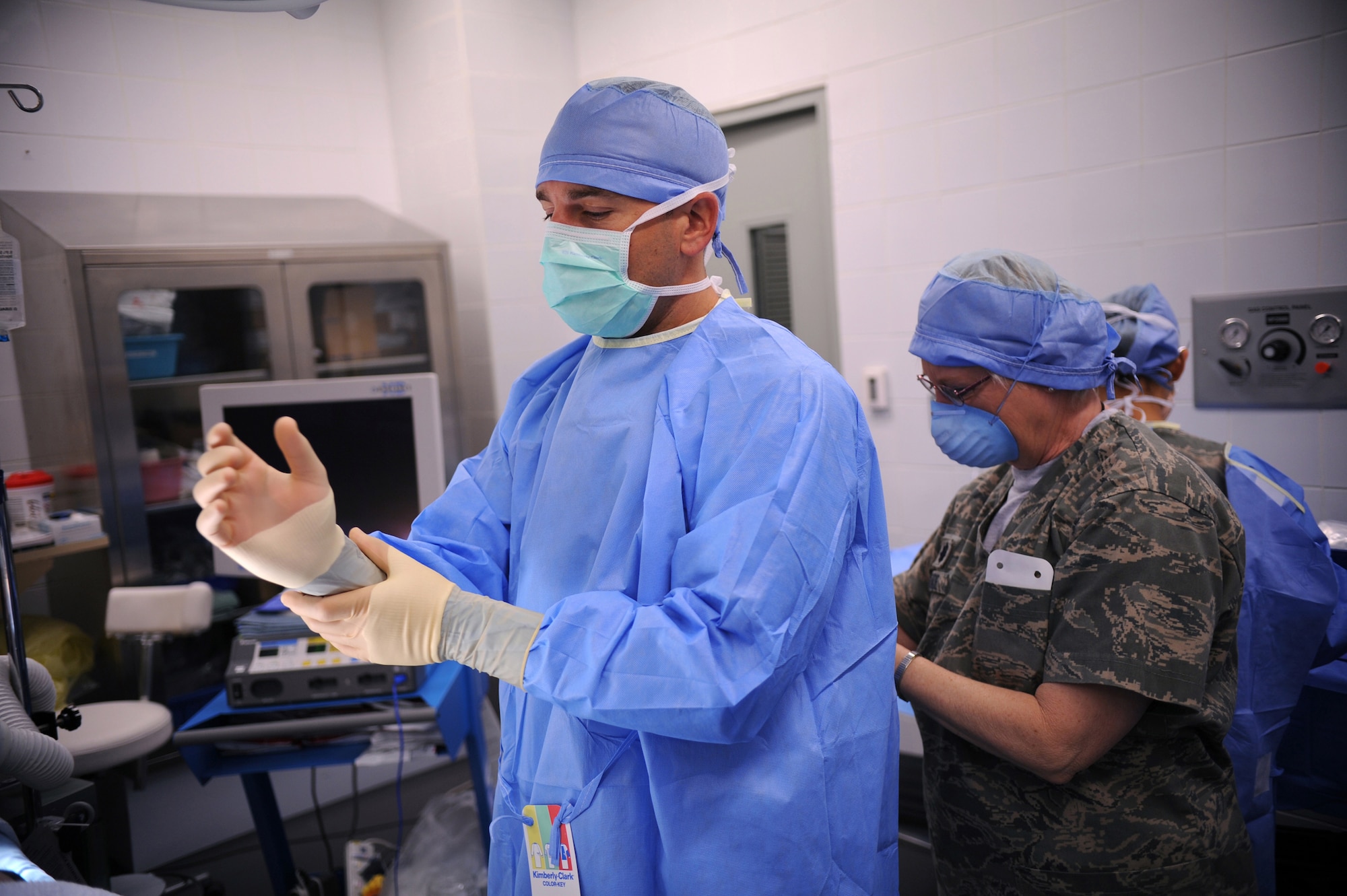 Lt. Col. Glory Meade, 379th Expeditionary Medical Group perioperative nurse, helps Major (Doctor) Brian Holt, 379th Expeditionary Medical Group general surgeon, don his sterile surgical attire in preparation for an operation, June 5, 2009, at an undisclosed location in Southwest Asia.  This specific surgery allows the patient to return to duty quicker and with less pain.  The surgeries performed here range from elective to acute emergencies.  The surgical team provides treatment for patients coming in from all over the U.S. Central Command's Area of Responsibility.  Lt. Col. Meade hails from Dayton, Ohio and is deployed from Wright Patterson Air Force Base, Ohio.  Major Holt hails from St. Peters, Mo. and is deployed from Misawa Air Base, Japan.  Both are deployed in support of Operations Iraqi and Enduring Freedom and Combined Joint Task Force - Horn of Africa.  (U.S. Air Force photo/Senior Airman Andrew Satran/released)