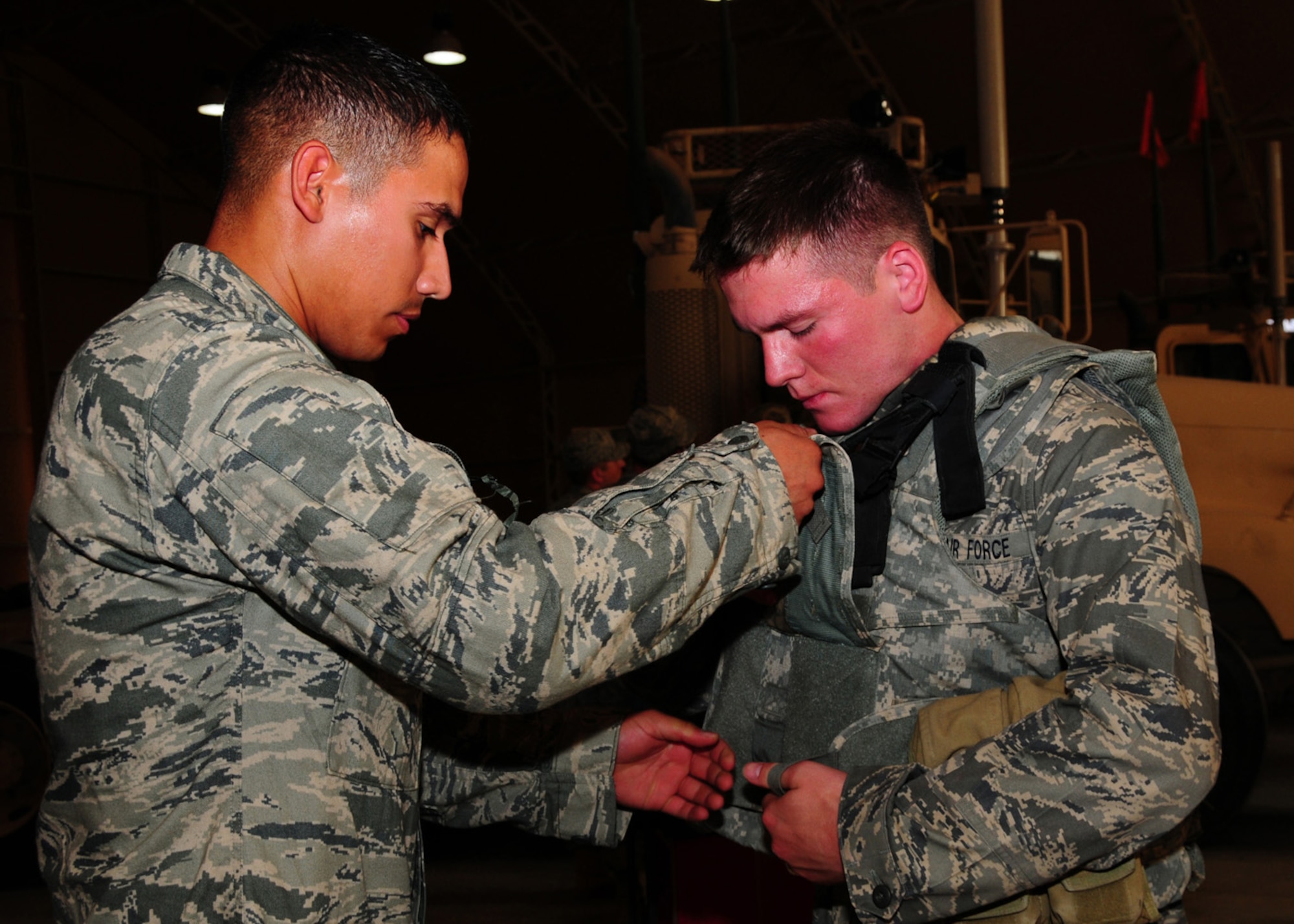 SOUTHWEST ASIA -- Senior Airman Sanchez Zepeda, 586th Expeditionary Logistics Readiness Squadron load master driver, assists Air Force Cadet Nathanael Thalhofer with properly securing body armor at an Army base in Southwest Asia, June 8. Operation Air Force is an annual program that places Air Force Academy cadets at operational Air Force bases throughout the world for career shadowing, mentoring and familiarization. Airman Zepeda is deployed from F.E. Warren Air Force Base, Wyo., and hails from Auburn, Wash. Cadet Thalhofer hails from Vashon Island, Wash. (U.S. Air Force photo/Senior Airman Courtney Richardson)