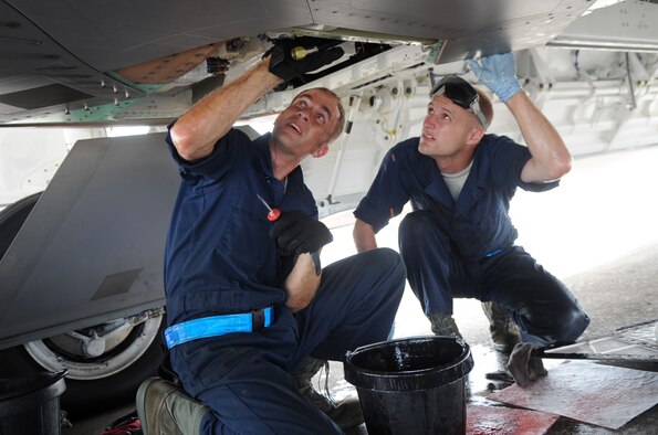 ANDERSEN AIR FORCE BASE, Guam - Staff Sgt. Jeremiah Smith and Senior Airman Theodore Cupp, F-22 Raptor crew chiefs from the 525th Expeditionary Aircraft Maintenance Unit deployed from Elmendorf Air Force Base, Alaska, perform maintenance on a hydraulic pump June 3. The Airmen are deployed to Andersen Air Force Base, Guam, in support of U.S. Pacific Command’s Theatre Security Package.  (U.S. Air Force photo by Senior Airman Christopher Bush)