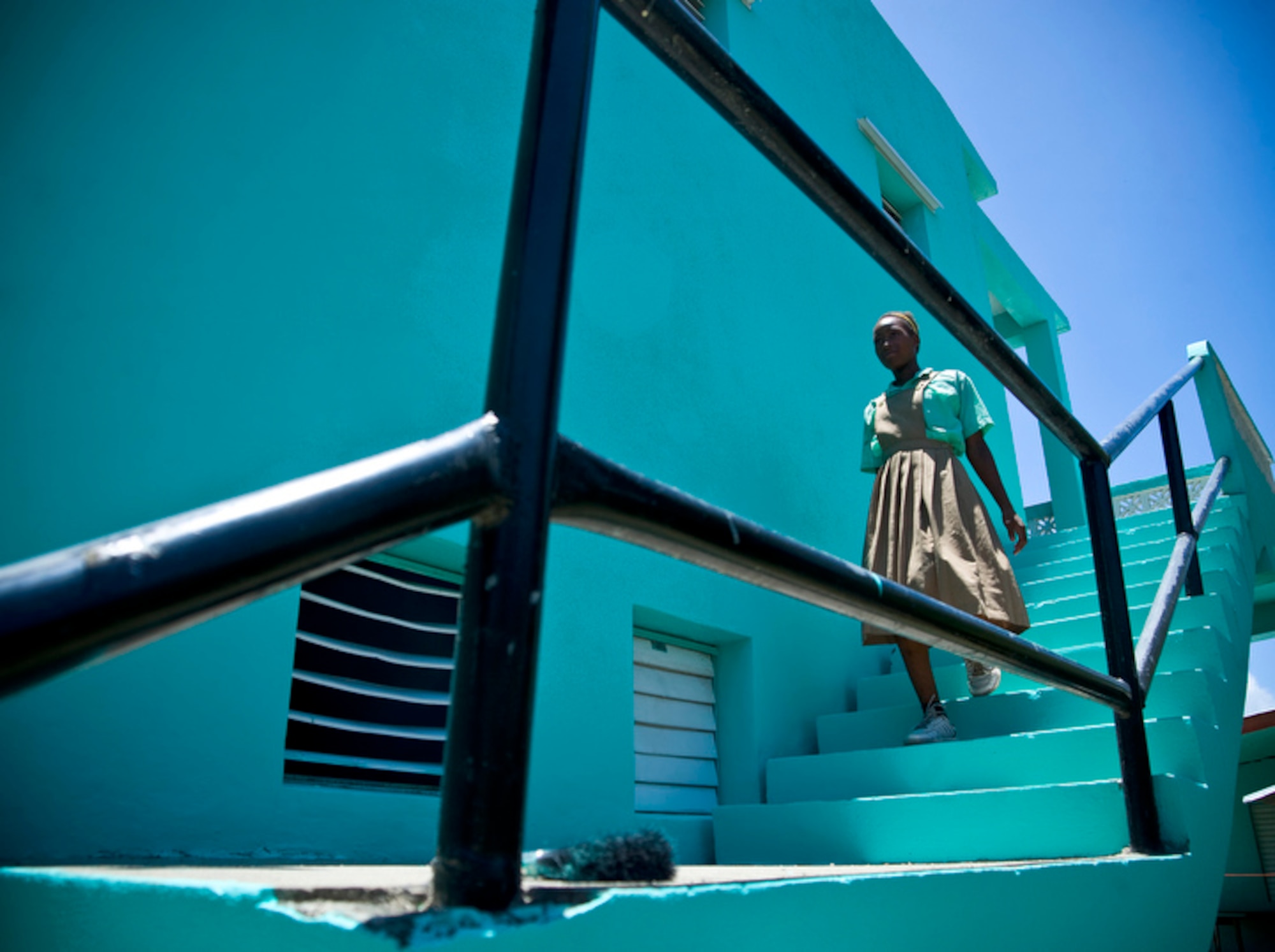 A young school girl makes her way down freshly painted stairwell at the Stella Maris School for the Physically Disabled June 8 in Belize City, Belize. Airmen deployed here for Operation Southern Partner spent the day painting the school exterior. (U.S. Air Force photo/Staff Sgt. Bennie J. Davis III)