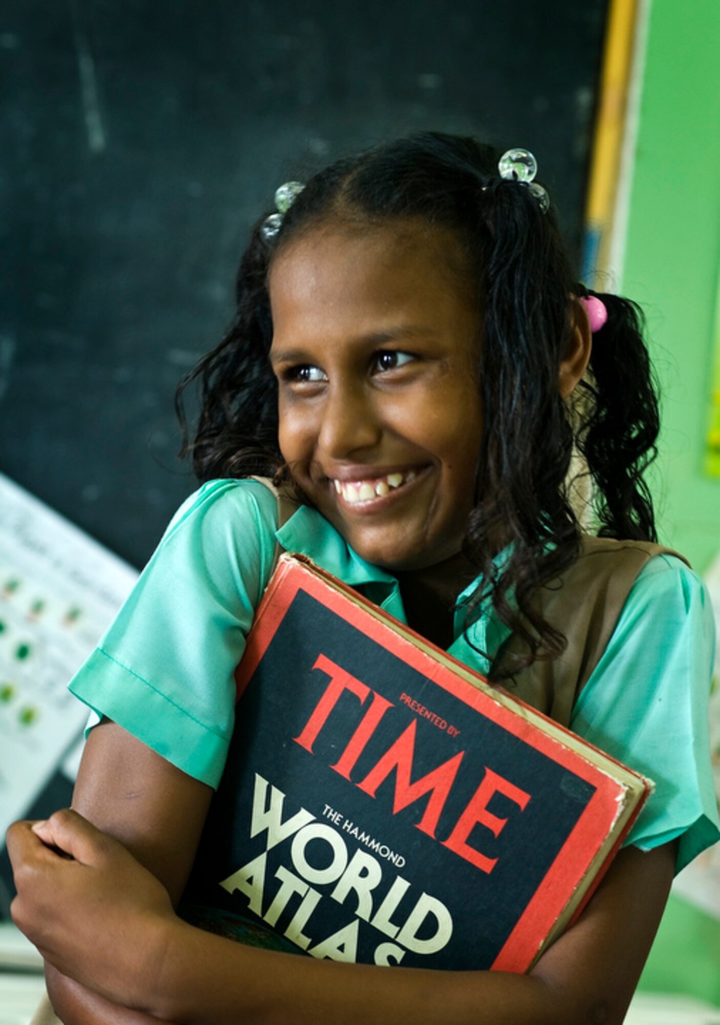 An 11 year-old schoolgirl holds her favorite book while talking to classmates about the Airmen deployed from Operation Southern Partner who are outside painting the Stella Maris School for the Disabled June 8 in Belize City, Belize. (U.S. Air Force photo/Staff Sgt. Bennie J. Davis III)